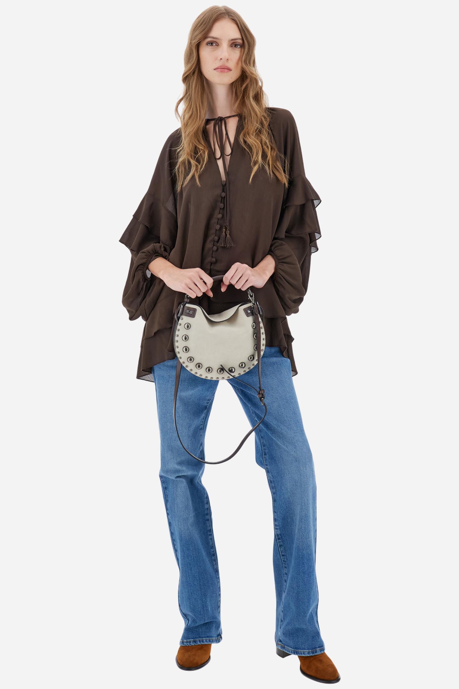 Women's blouse with long sleeves in solid-colour chiffon with mandarin collar and V-neckline closed by ties and covered buttons. Loose fit with longer back and wide ruffles on sleeves and hem. The logo appears on a small golden metal plate applied to the front hem. The model wears size 2. - Java