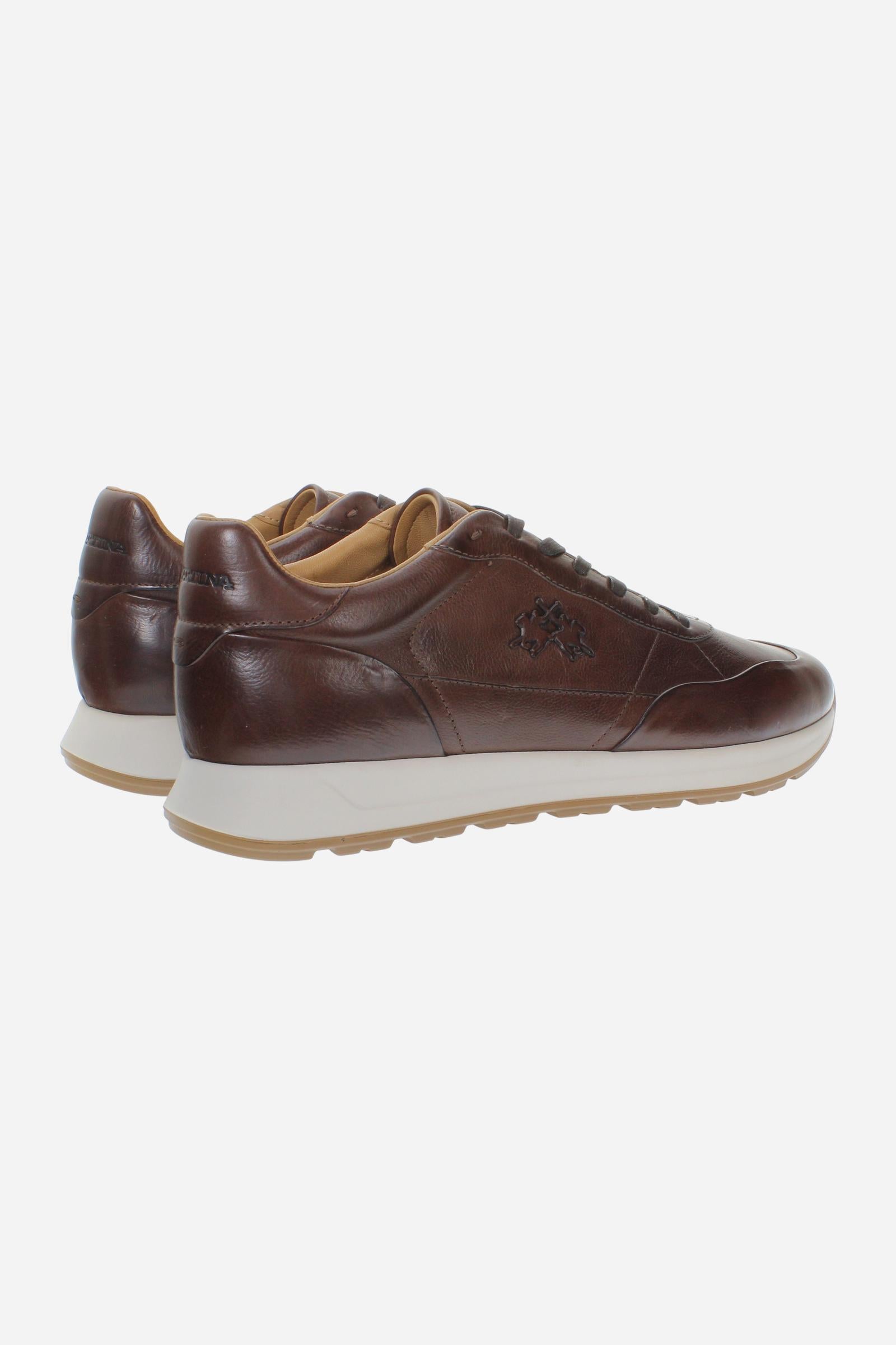 Men's sneaker crafted from soft vegetable-tanned leather with handcrafted stitching, embossed logo, two-tone rubber PU sole, and leather-colored lining. Made in Italy. - Brown