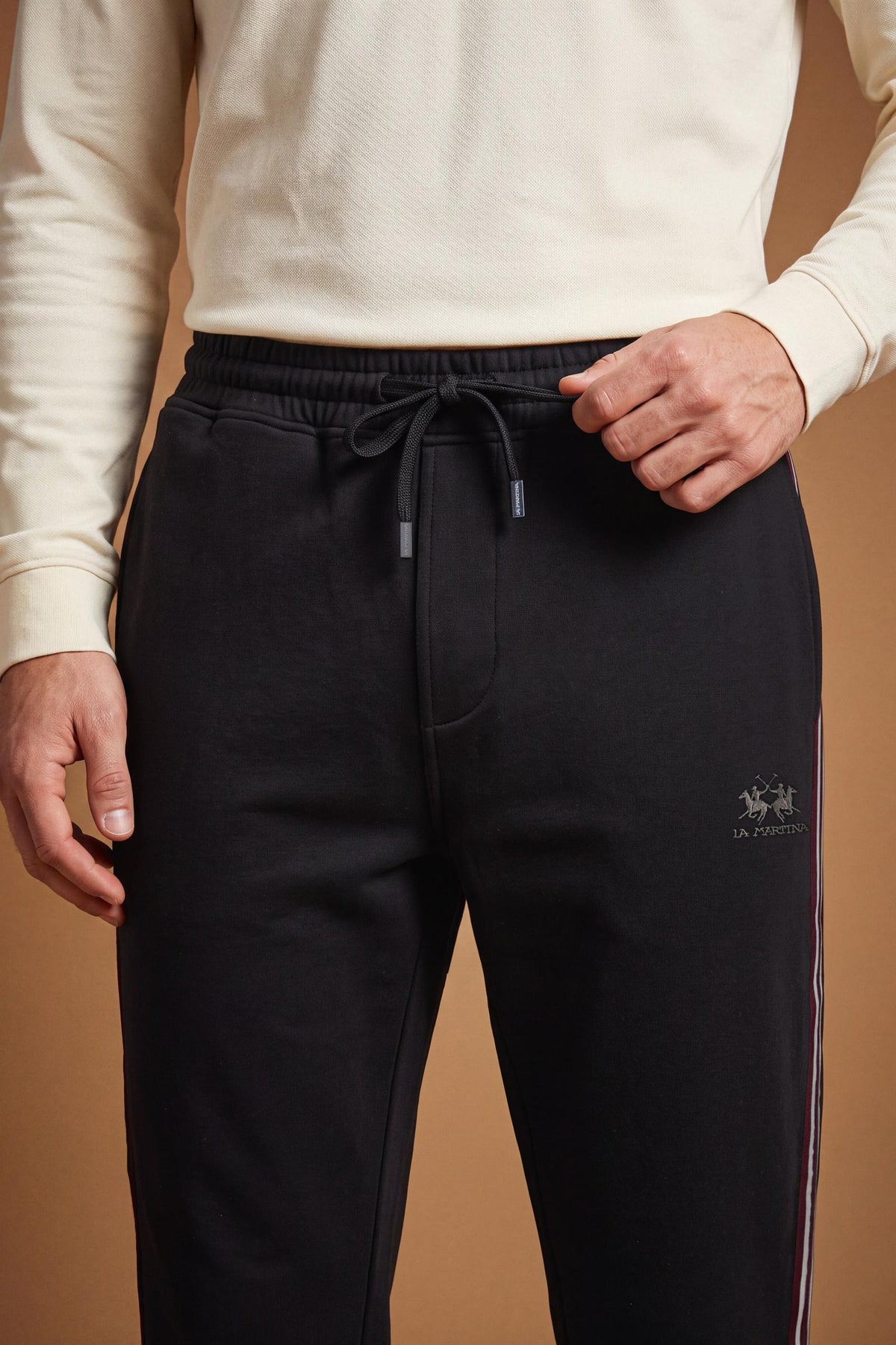 Men's cotton interlock jogging pants with elastic waistband, adjustable drawstring, side and back pockets, multicolored stripes, and a soft, sporty silhouette. - Black