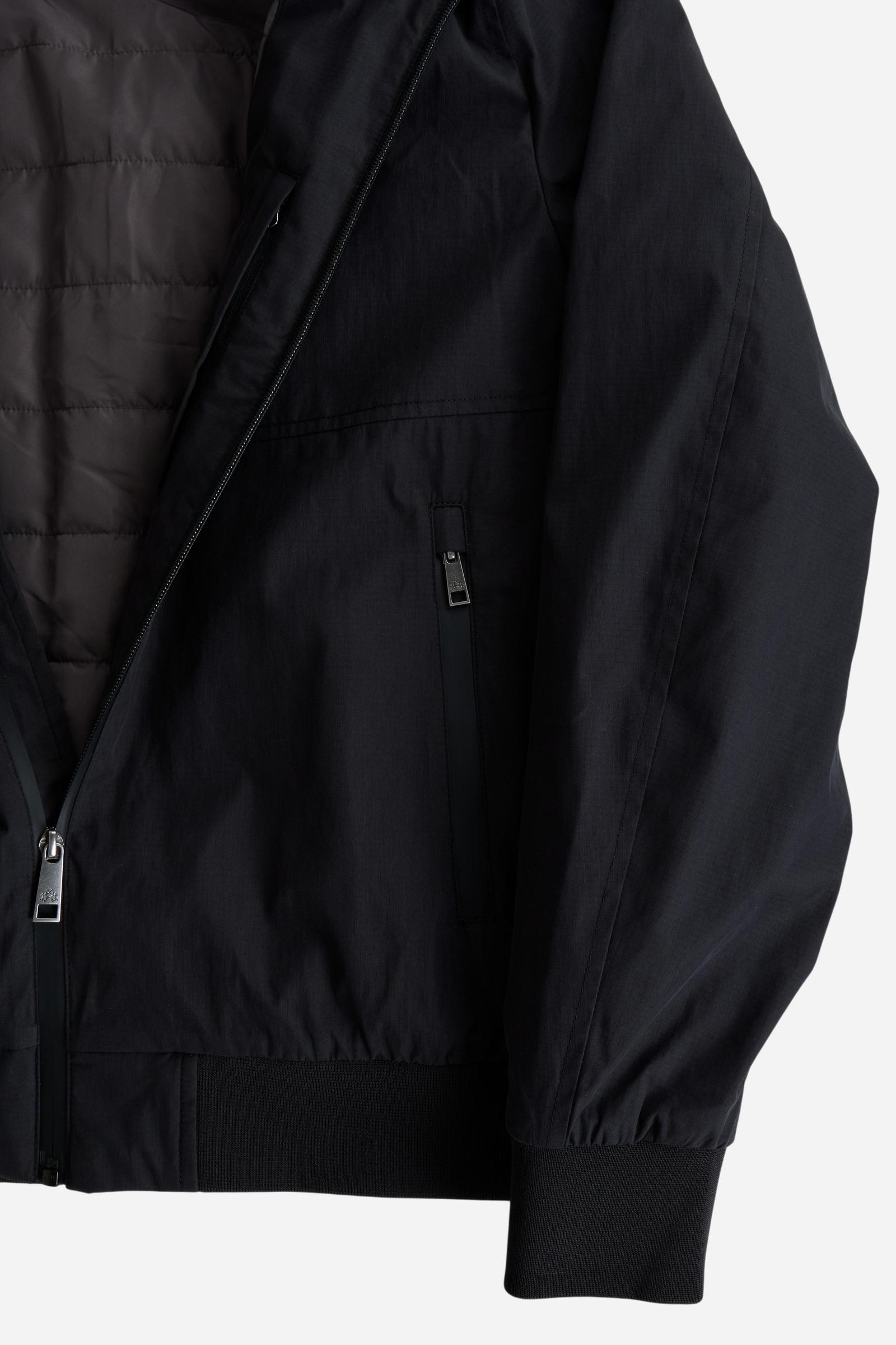 Men's padded jacket in cotton-polyamide blend for comfort and durability. Features high collar, zip closures, elastic ribbed trims, and polyester quilted lining - Black