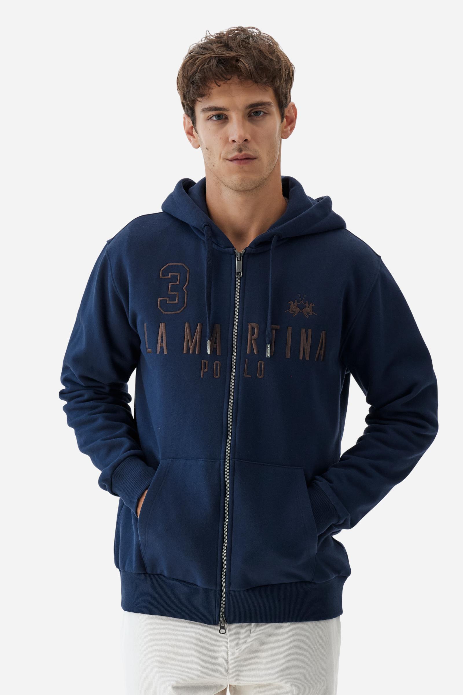 Men's long-sleeved hoodie in solid colour, made from soft 100% cotton fleece with a velvety touch. The model features a customised front zip and an adjustable hood with drawstring. Hem and cuffs in tone-on-tone rib. Iconic brand graphics stand out on the chest, embroidered with numbers and lettering. Regular fit ensuring comfort and freedom of movement. Model wears size L. - Navy