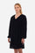 Women's knee-length dress with long sleeves and V-neck on both the front and back. It is made of velvet-effect polyester in a solid colour and features a regular fit, following the England line. The cuff has an elastic band and the side pockets add practicality to the dress. In addition, there is a crown patch logo at the bottom of the dress. Suitable for both the office and more informal occasions. The model is 174 cm tall and wears a size 2. - Black