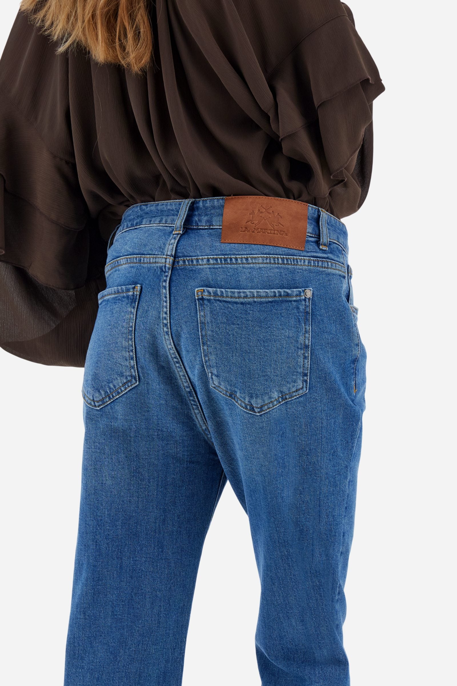 Women's stretch denim jeans. Classic 5-pocket style with regular fit and cigarette legs. The jacron label is applied to the back of the waistband, where the brand logo appears. The model is wearing a size 28. - Medium Indigo Denim