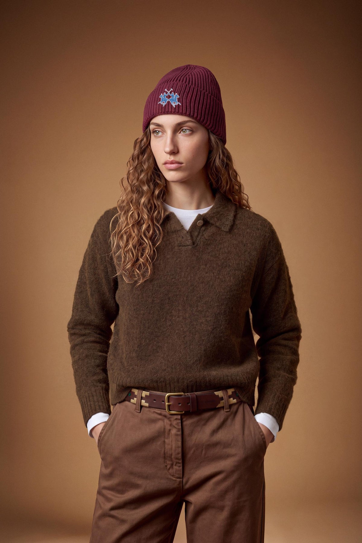 Women's long-sleeve knitted polo in soft lambswool blend, featuring a relaxed cropped fit, ribbed cuffs, shirt-style collar, and smooth, compact knit surface. - Hot Fudge