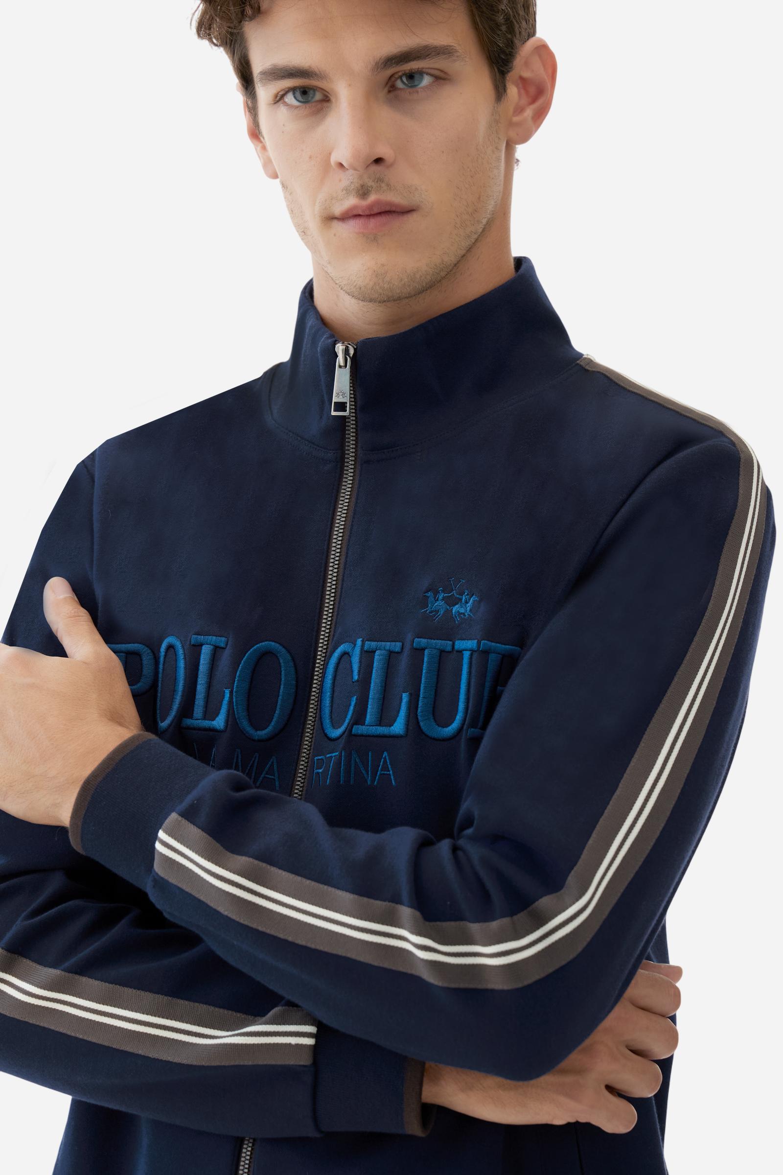 Men's long-sleeved, full-zip sweatshirt. Made of soft solid colour cotton fleece. The neck and cuffs and waistband are in solid colour ribbed knit with contrasting edging. Front zip opening and Polo club guarantee label applied to the edge inside the collar. The front lettering is a large tone-on-tone raised embroidery. A narrow two-tone striped band is applied to the shoulders and sleeves. Regular fit. The model is wearing a size L. - Navy