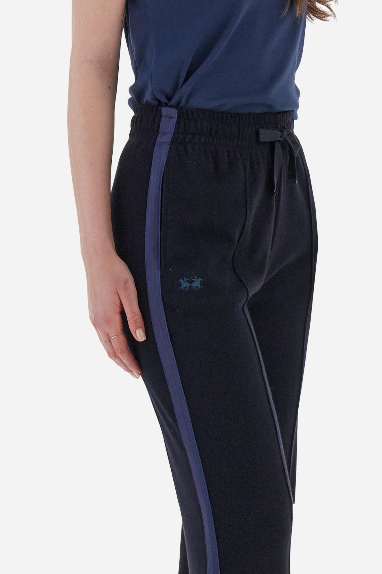 Women’s pants made of viscose-blend interlock fleece, soft and luxurious on the skin. Elastic waistband with adjustable drawstring ensures optimal comfort. Side pockets and bicolor striped tape along the sides complete the design. A small tonal embroidered logo enriches the front. Straight leg with slightly flared hem for a feminine, elegant twist in athleisure style. Model wears size 2. - Navy