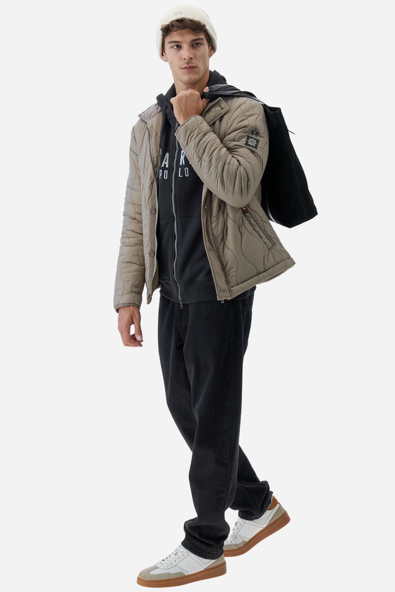 Men's long-sleeved hoodie in solid colour, made from soft 100% cotton fleece with a velvety touch. The model features a customised front zip and an adjustable hood with drawstring. Hem and cuffs in tone-on-tone rib. Iconic brand graphics stand out on the chest, embroidered with numbers and lettering. Regular fit ensuring comfort and freedom of movement. Model wears size L. - Black