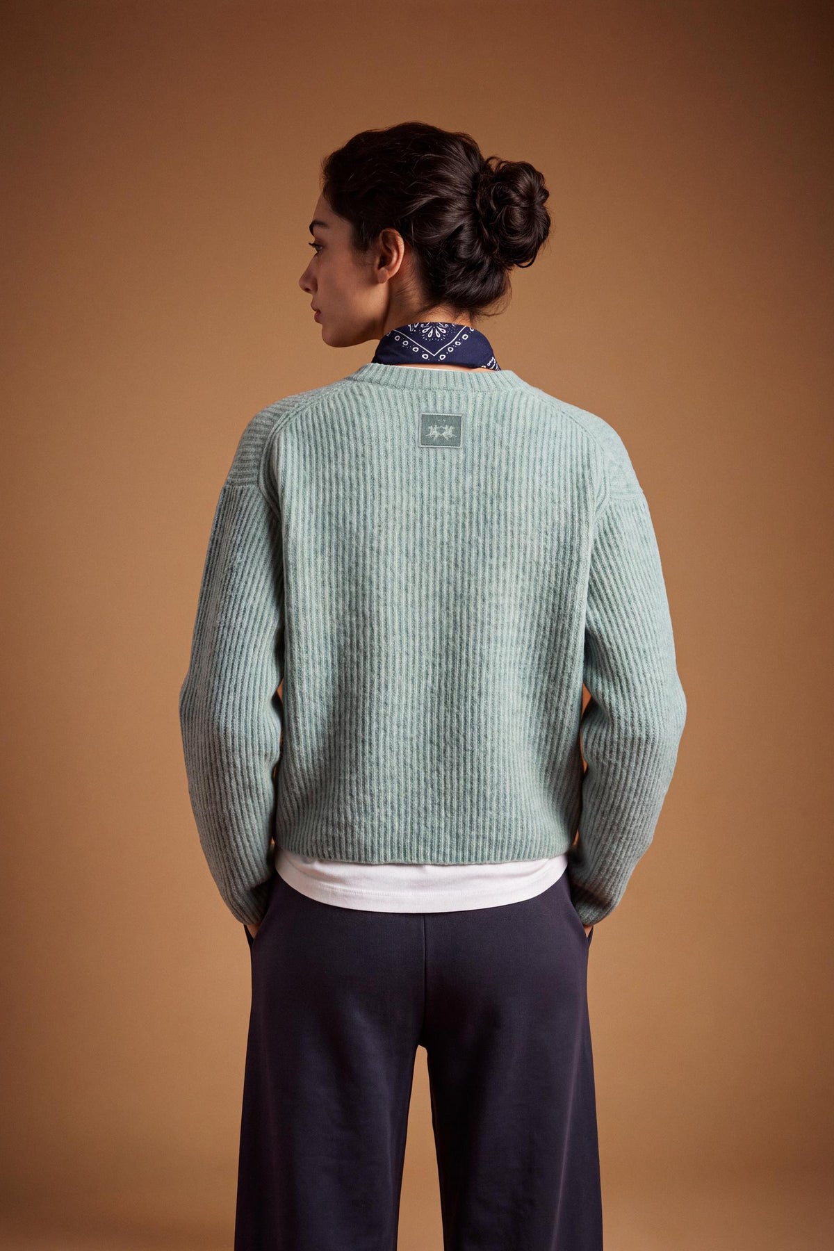 Soft lambswool women's sweater with vertical ribbed knit, relaxed fit, dropped shoulders, cropped length, and a subtle embroidered logo on the back neckline. - Desert Sage