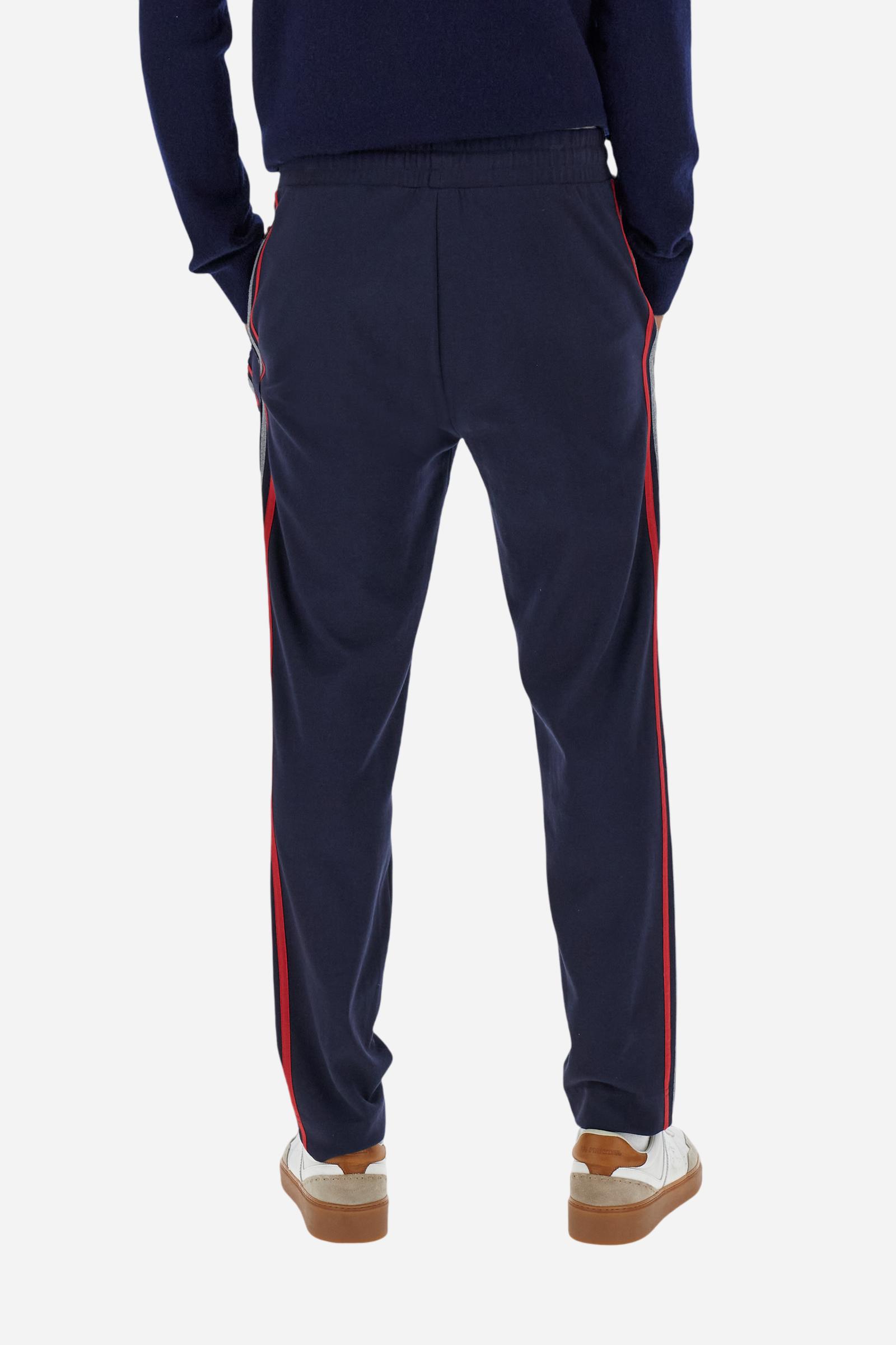 Men’s joggers made of cotton fleece with elastic waistband and contrast drawstring finished with personalized metal tips. Side inset pockets and colorful side bands add a dynamic touch. A central vertical crease on the leg refines the sporty design. Small embroidered logo in contrast under the left pocket. Regular straight-leg fit for a modern, everyday look. Model wears size L. - Navy