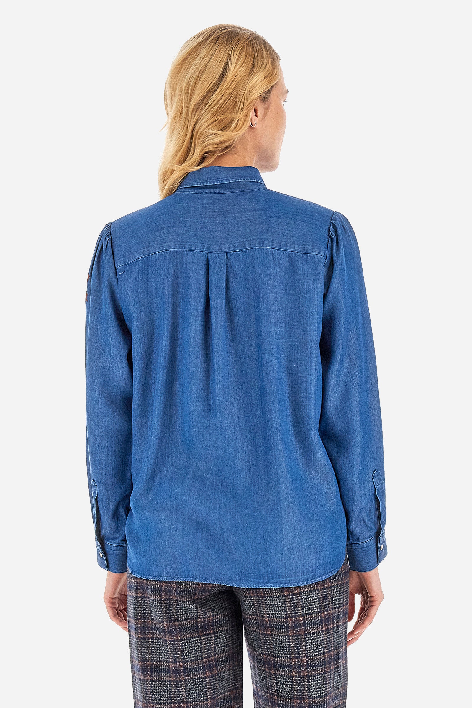 This long-sleeved women's shirt with a regular fit is made of solid-coloured denim fabric, characterised by the rouge on the front profile that covers the buttons and by the classic collar. An embroidered crown logo on the sleeve completes the overall look. This garment is perfect for creating a casual and versatile outfit. The model is 174 cm tall and wears a size 2. - Medium Indigo Denim