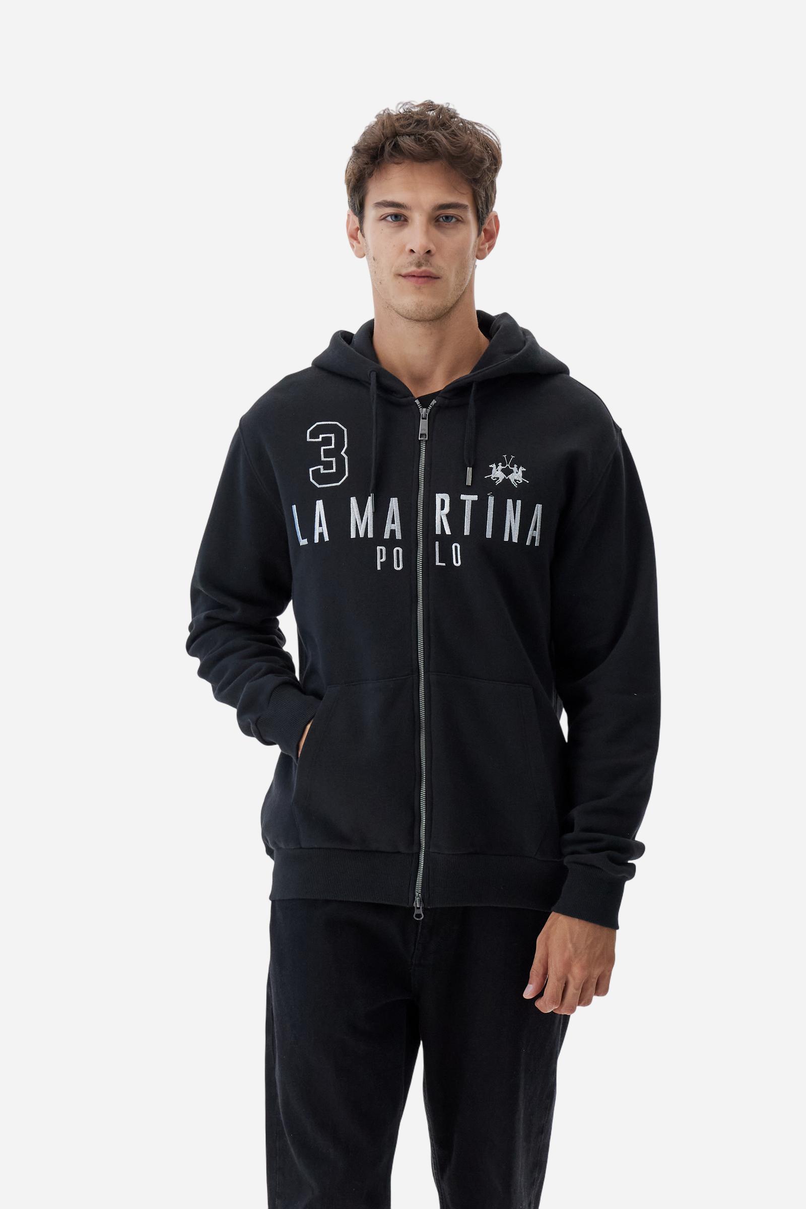 Men's long-sleeved hoodie in solid colour, made from soft 100% cotton fleece with a velvety touch. The model features a customised front zip and an adjustable hood with drawstring. Hem and cuffs in tone-on-tone rib. Iconic brand graphics stand out on the chest, embroidered with numbers and lettering. Regular fit ensuring comfort and freedom of movement. Model wears size L. - Black