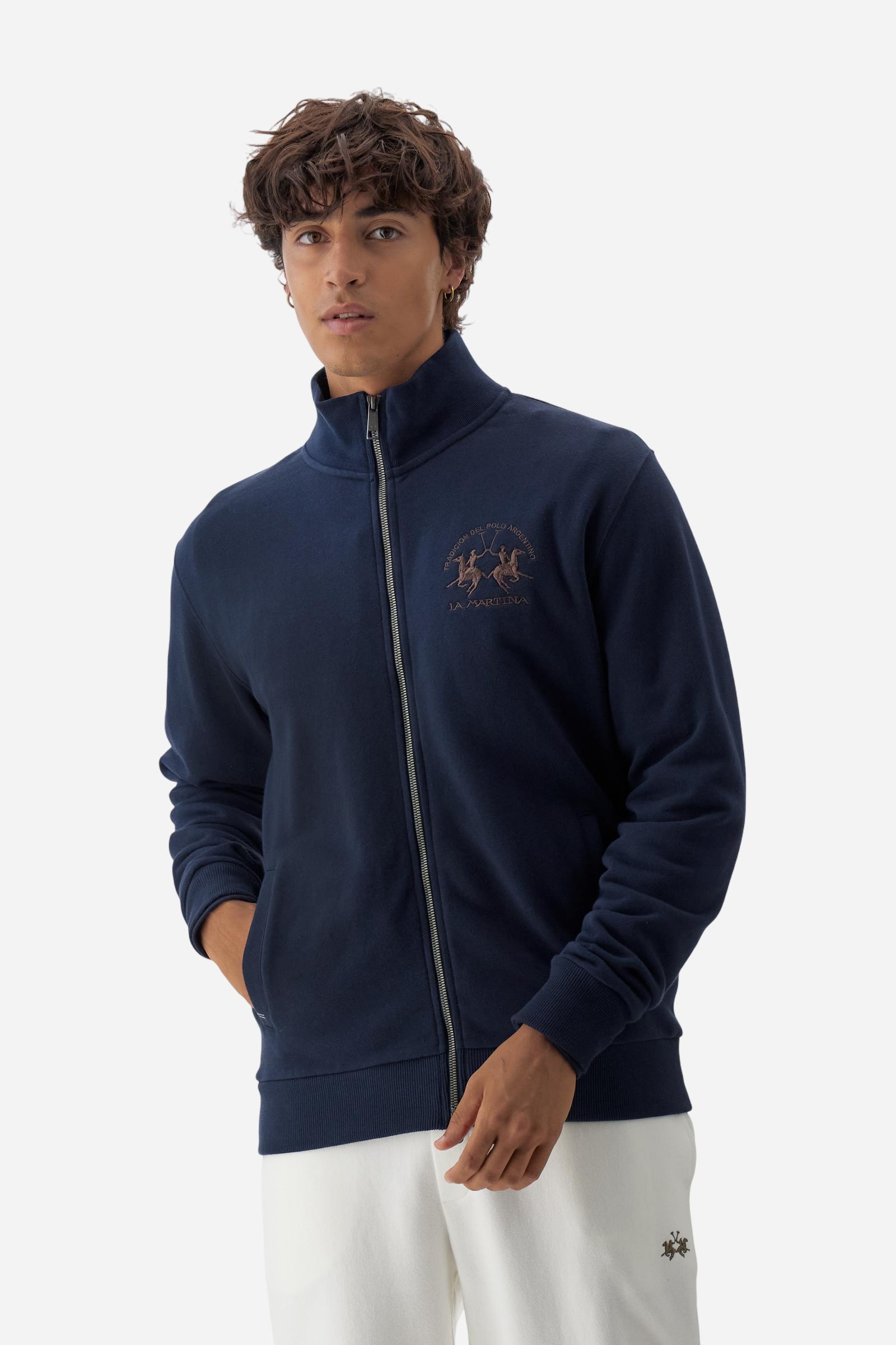 Men's long-sleeved solid colour sweatshirt. It is made of comfortable 100% cotton fleece with a soft-brushed feel. Model with high ribbed neck and front zip opening. Solid colour ribbed cuffs and waistband. The large contrasting brand team logo is embroidered on the chest. A contrasting colour fabric number patch is applied to the right sleeve. The model has a regular fit that offers a comfortable, relaxed silhouette. The model is wearing a size L. - Navy