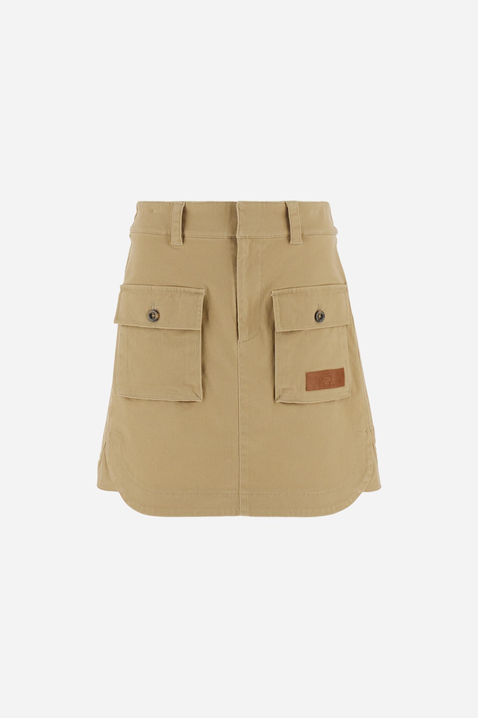 Women’s mini skirt in solid-colour stretch cotton twill. Front closure with zip and internal hook, elasticated back waistband for added comfort. Applied front pockets with personalised horn-effect buttons and decorative flaps on the back. Logo on faux leather label applied to the front pocket. Flared, fluid silhouette for a feminine and comfortable look. The model wears size 2. - Travertine