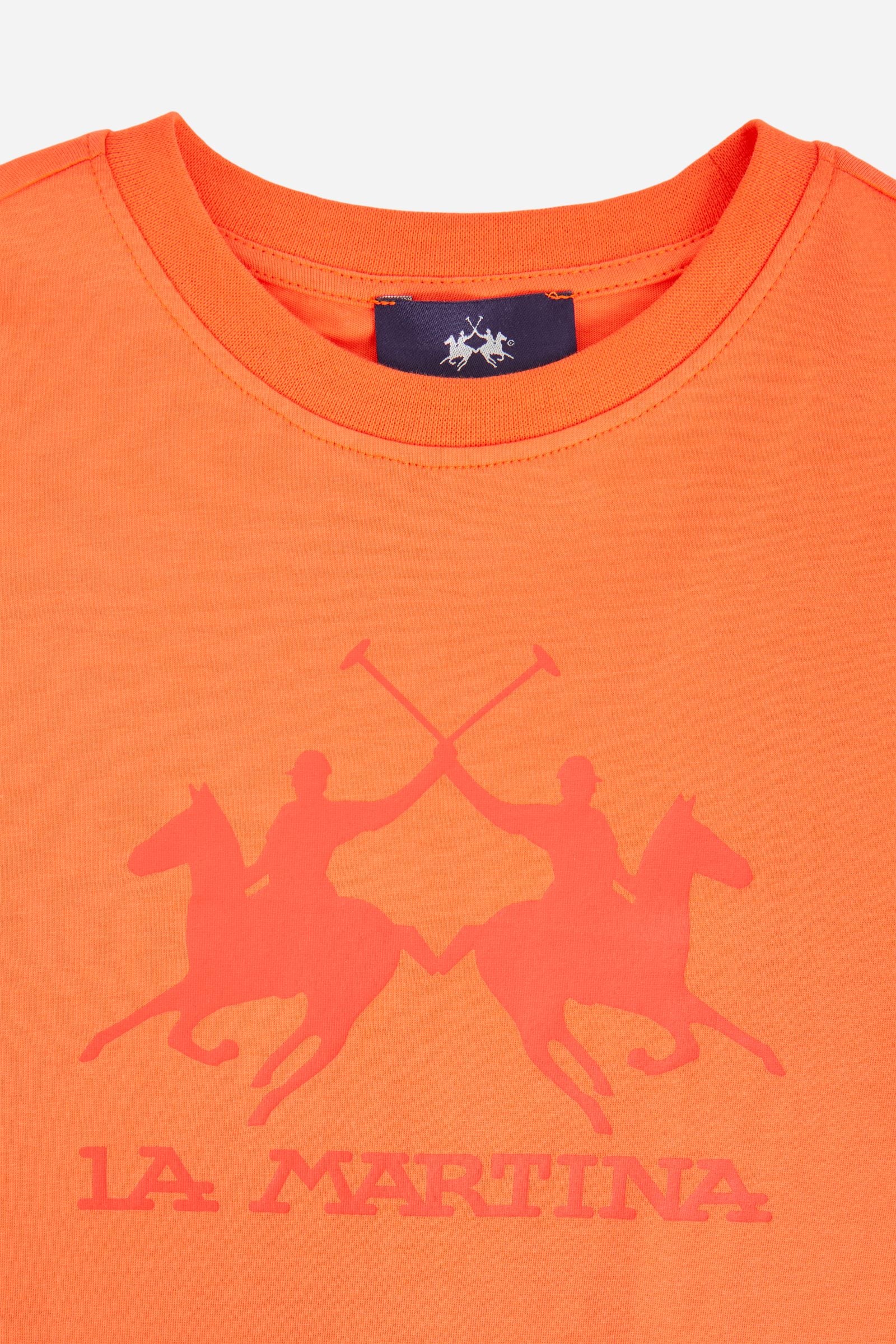 Short-sleeved T-shirt for boys made from soft 100% cotton jersey in a solid colour. The style features a regular fit and tonal ribbed crew neck. The maxi front print, featuring the iconic crossed polo players logo and La Martina lettering, gives the garment strong visual impact and a bold sporty style. - Flame