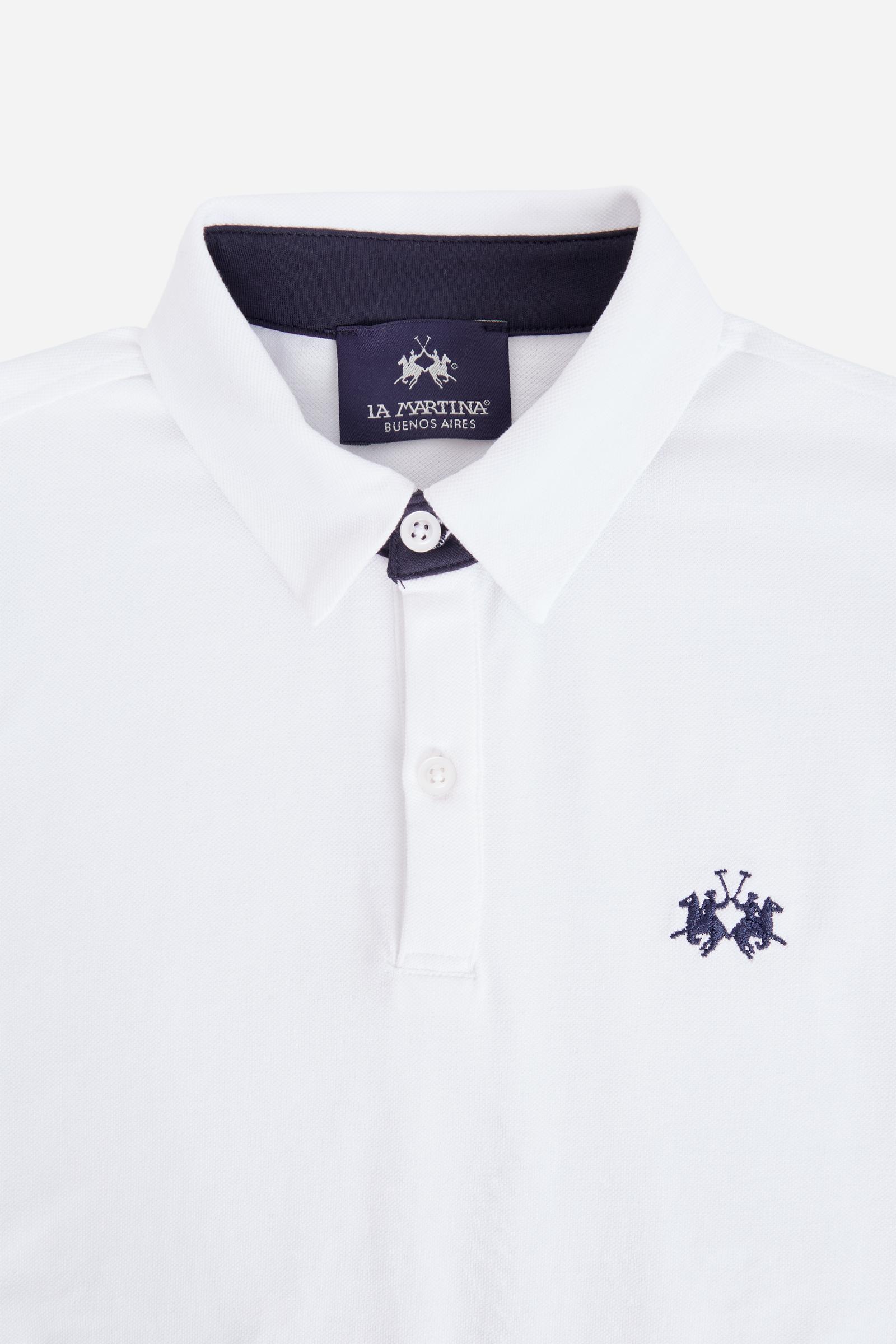 Short-sleeved polo shirt for boys made from soft 100% cotton piqué in a solid colour. The classic style features a regular fit, piqué collar and two-button front closure. The contrast inner collar detail and the multicolour logo embroidered on the chest enrich the garment. The detail under the collar completes the design with a distinctive touch. - Optic White