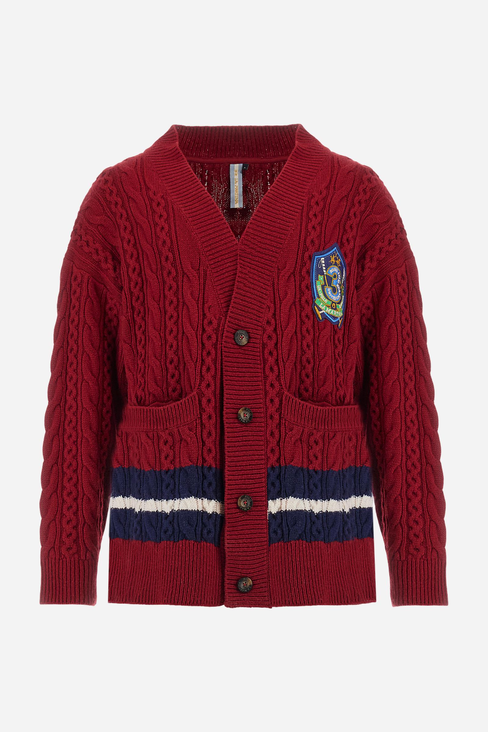 Men’s cardigan with long sleeves in solid-colour lambswool with cable-knit pattern for a refined and classic look. Deep neckline, ribbed cuffs and hem, closure with personalised horn-effect buttons. Applied front pockets and bicolour bands on the hem reflecting the chest patch colours. Oversized fit with dropped shoulders for a modern silhouette. The model wears size L. - Chili Pepper