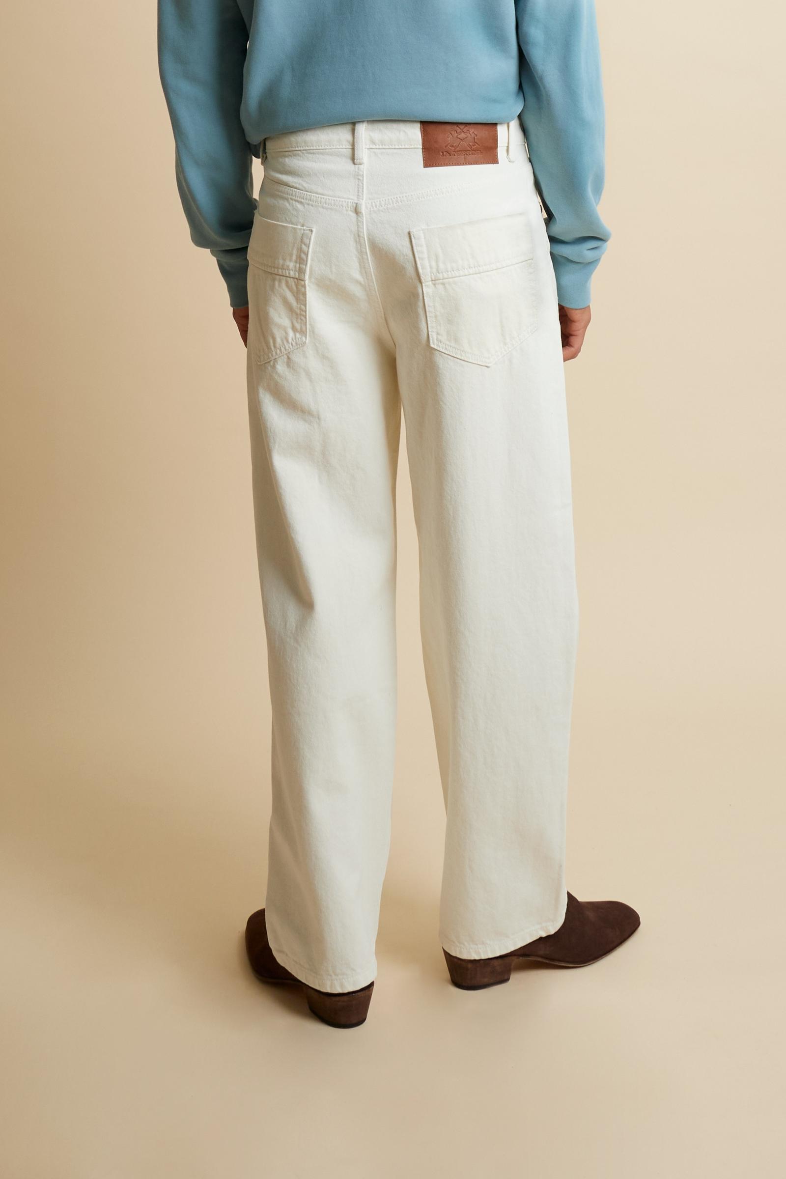 Men’s long trousers made from durable 100% cotton drill, characterized by a compact structure that ensures long-lasting wear and shape retention. The five-pocket construction recalls classic workwear aesthetics, with custom metal rivets and tonal reinforcement stitching that enhance durability. The leather back patch with contrasting logo and the internal waistband embroidery add exclusive details. The fit is relaxed, with a straight leg from hip to hem for comfort and ease of movement. An essential piece w