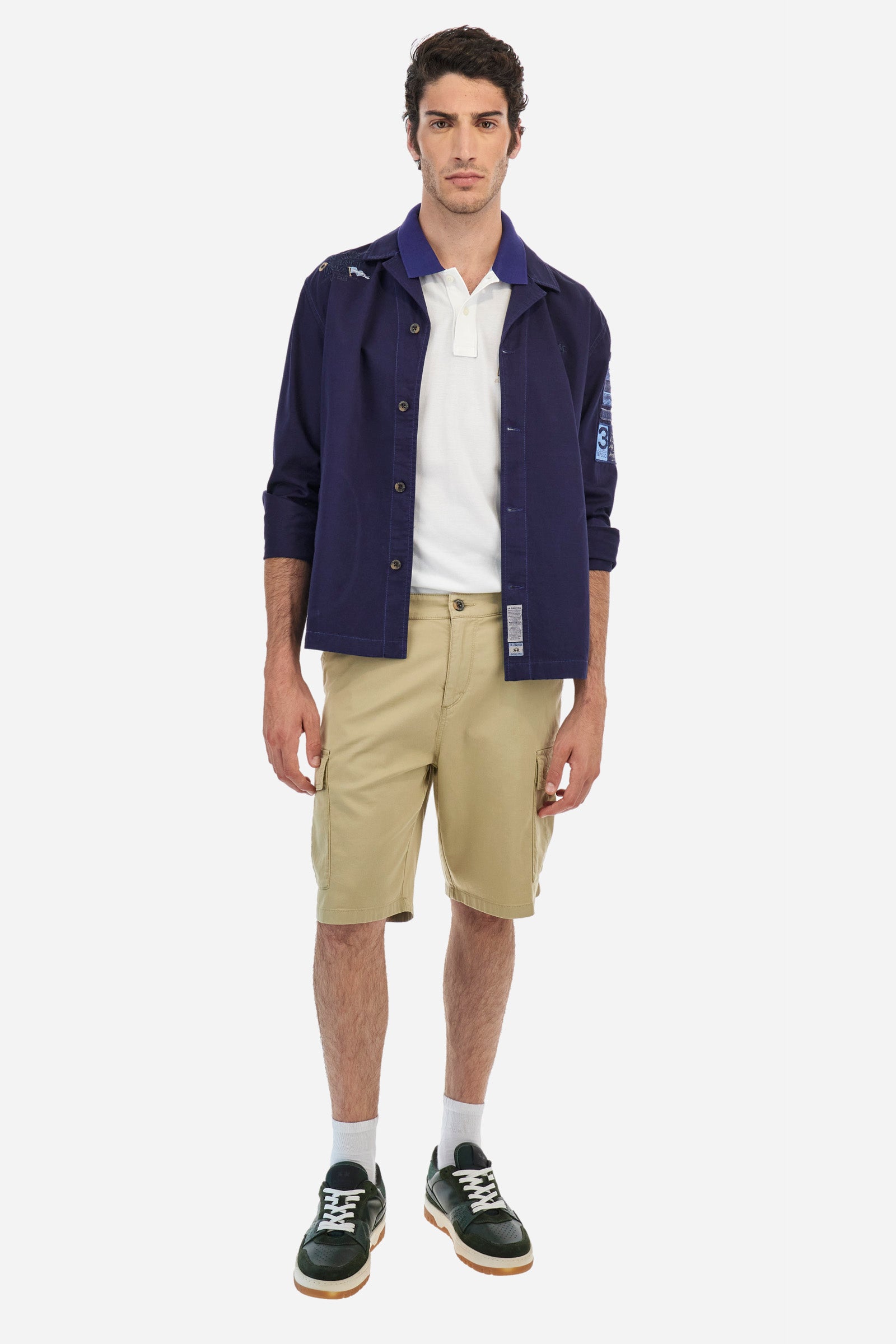 Men's single-colour Bermuda shorts in cotton twill. There are two American pockets, two cargo pockets and two back pockets. With belt loops. Zip and button fastening. The logo is embroidered tone-on-tone on the left cargo pocket. Regular fit. The model is wearing a size 33. - Twill