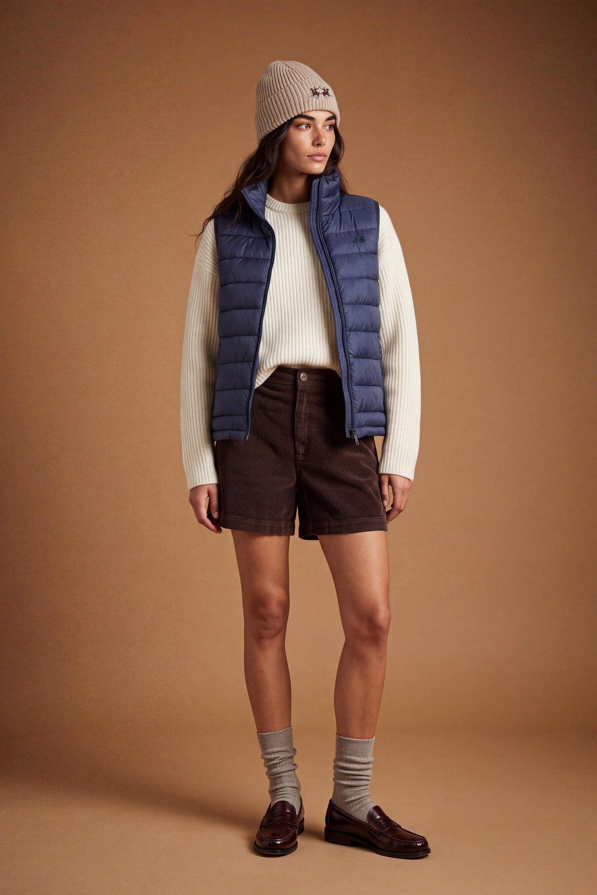 Women's nylon vest with polyamide lining and polyester padding, featuring horizontal quilting, high collar, zip closure, fleece-lined pockets, and adjustable hem for comfort. - Navy Blazer