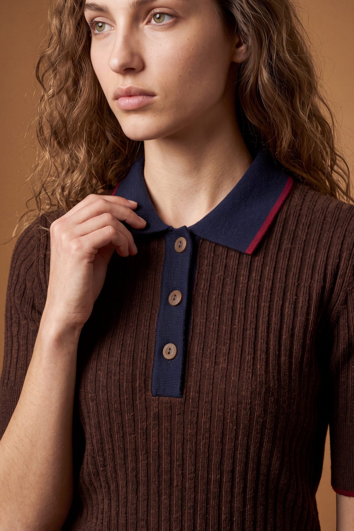 Slim-fit women's short-sleeve polo made from soft lambswool blend with vertical ribbing, ribbed collar, cuffs, and hem, featuring contrasting trims and a three-button front. - Dark Brown