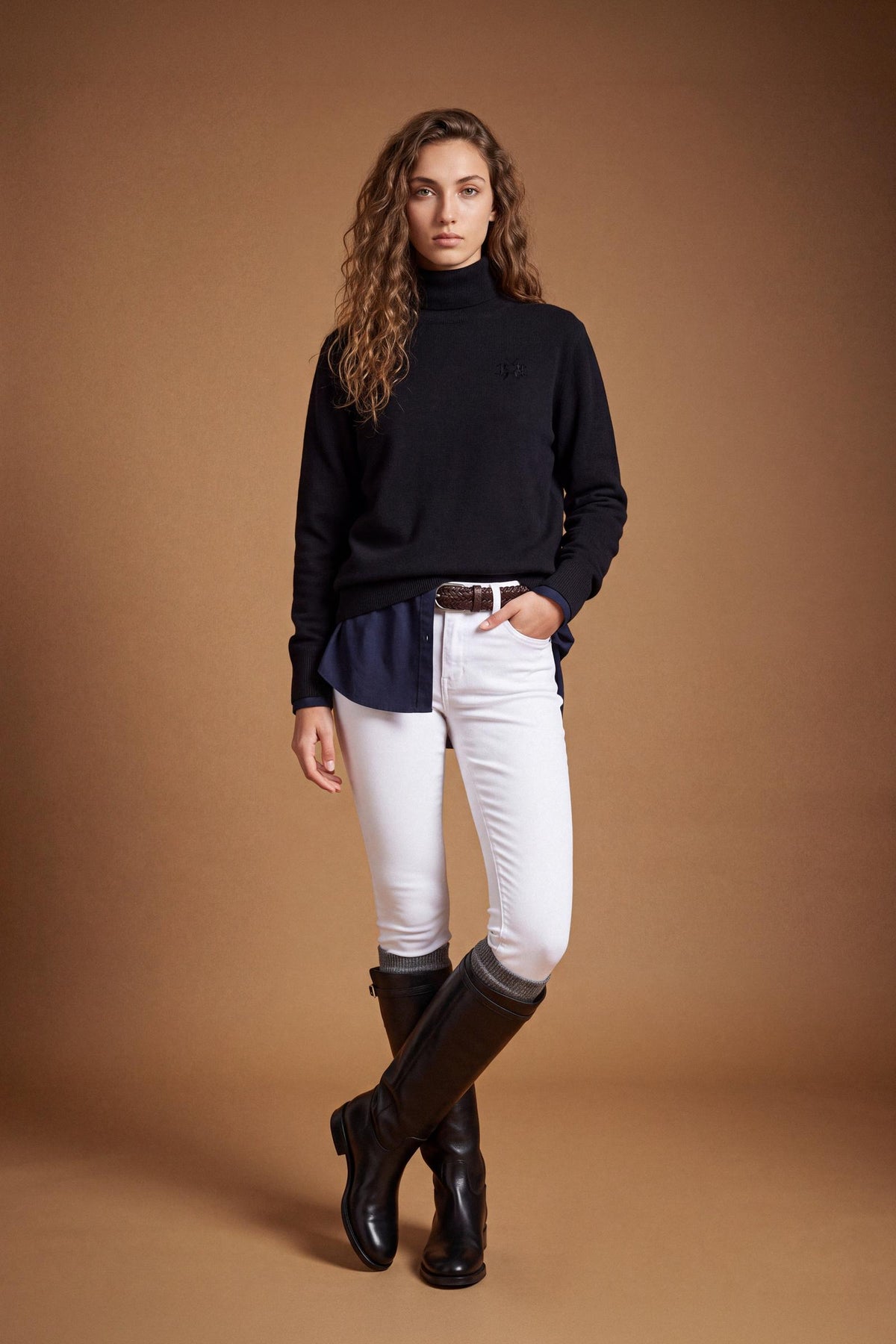 Women's lambswool turtleneck sweater with a soft, ribbed collar, fitted bust, ribbed cuffs and hem, and subtle embroidered logo for a clean, elegant look. - Black