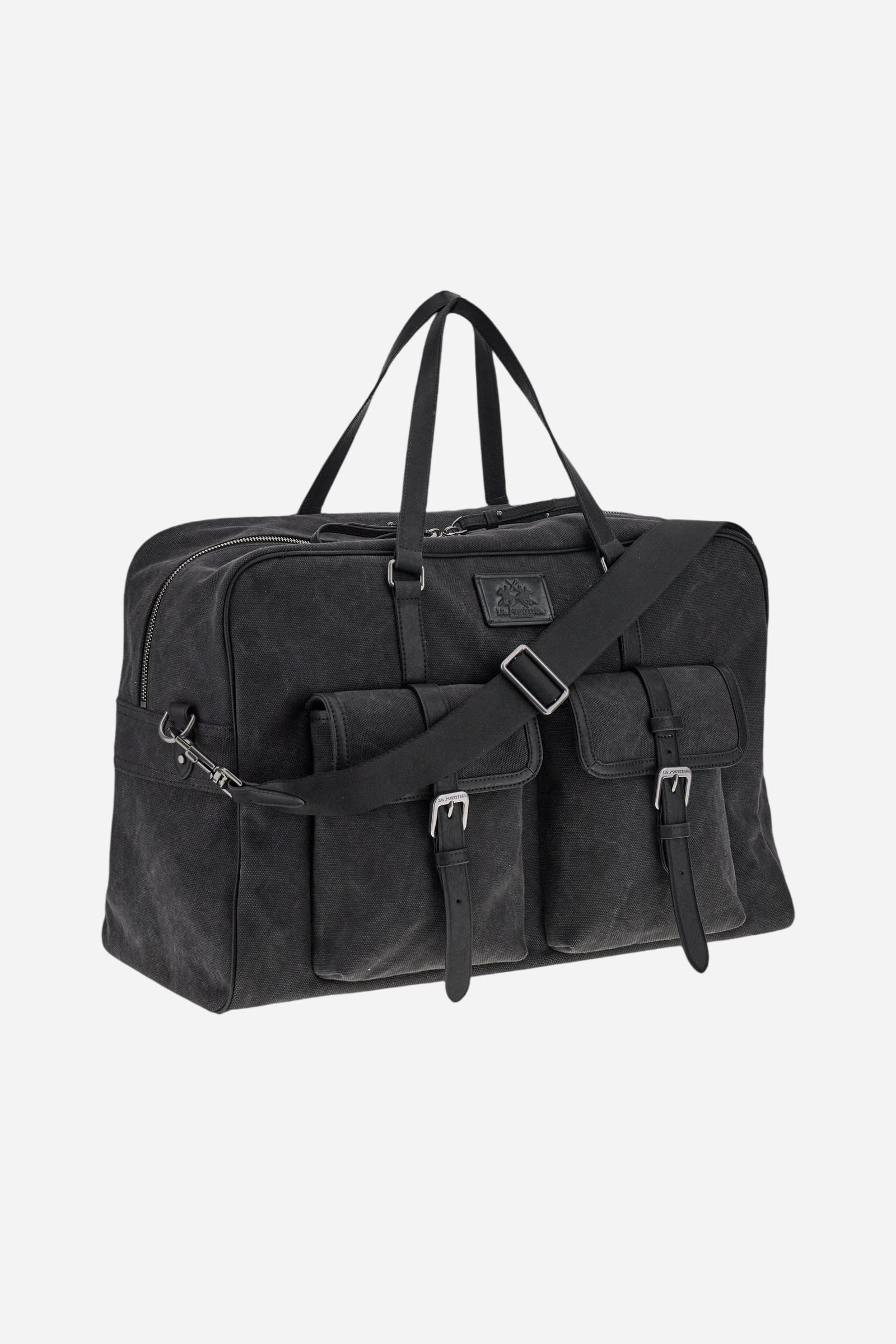 Travel bag in washed canvas and leather, roomy and functional, designed for practicality on trips. Secured with a zip and detachable shoulder strap, with large front pockets closed by metal buckles. The hot-stamped logo on the front leather tag completes the elegant design. Dimensions:46 x 33 x 22 - Black
