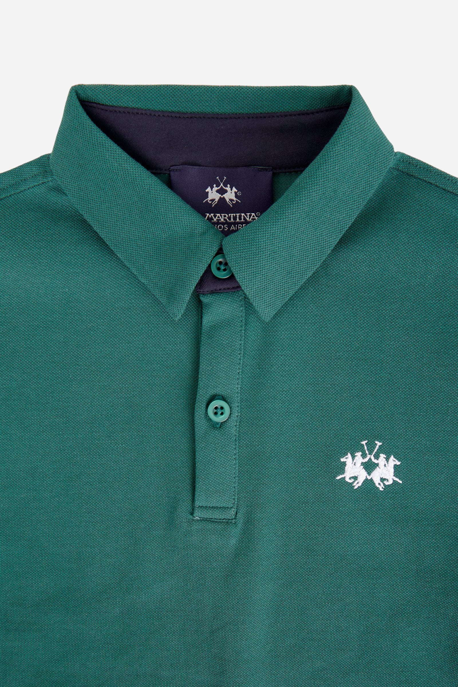 Short-sleeved polo shirt for boys made from soft 100% cotton piqué in a solid colour. The classic style features a regular fit, piqué collar and two-button front closure. The contrast inner collar detail and the multicolour logo embroidered on the chest enrich the garment. The detail under the collar completes the design with a distinctive touch. - Pineneedle