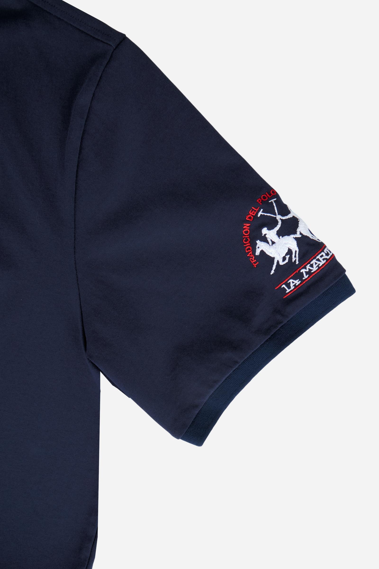 Numbered style with exclusive label, produced in only 100 pieces per style/colour. The label is positioned on the back, at the lower right, with the progressive number clearly visible. Short-sleeved polo shirt made from 100% cotton jersey. The contemporary-cut design features a modern, wide and relaxed silhouette, with a distinctly current streetwear touch. The collar is ribbed with contrast stripes, while the cuffs are ribbed tone-on-tone. The contrast number “1” on the chest, made from raw-edge finished f