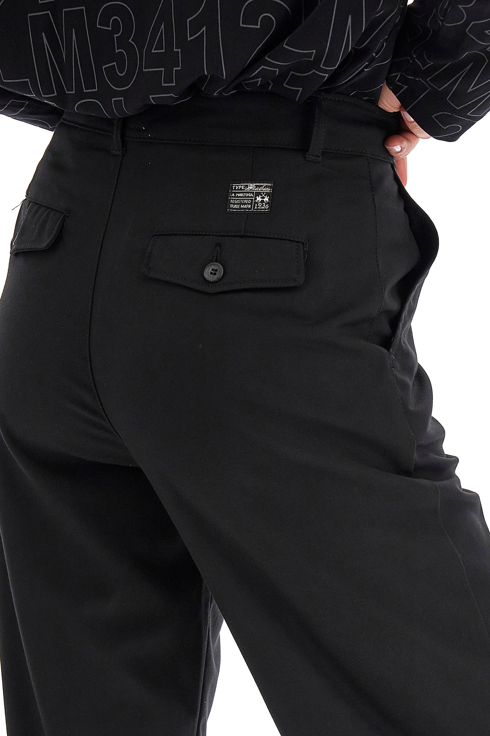Classic women's trousers made of stretch viscose to offer comfort and wearability. The button fastening, the welt pockets and the double back pocket guarantee practicality and functionality. The logo patch also adds a touch of understated style. The regular fit adapts perfectly to many body types, making these trousers a versatile choice for any occasion. The model is 174 cm tall and wears a size 2. - Black