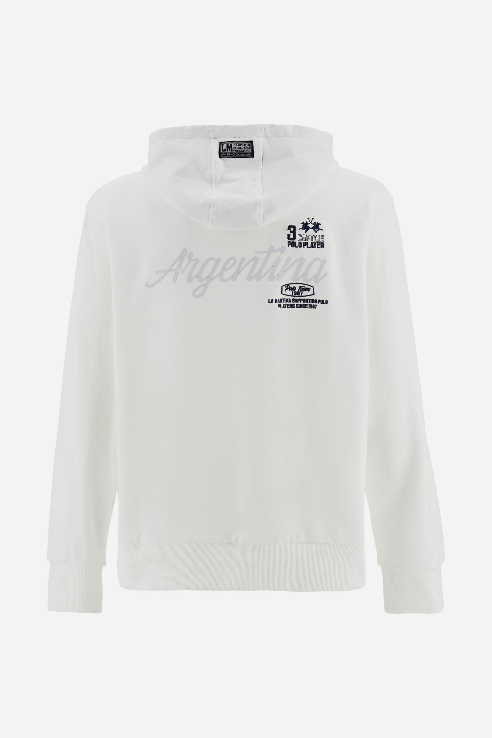 Men’s long-sleeve cotton French terry sweatshirt with a contrast jersey-lined hood, ribbed cuffs, navy embroidery, and a bold Argentina print on the back. - Optic White