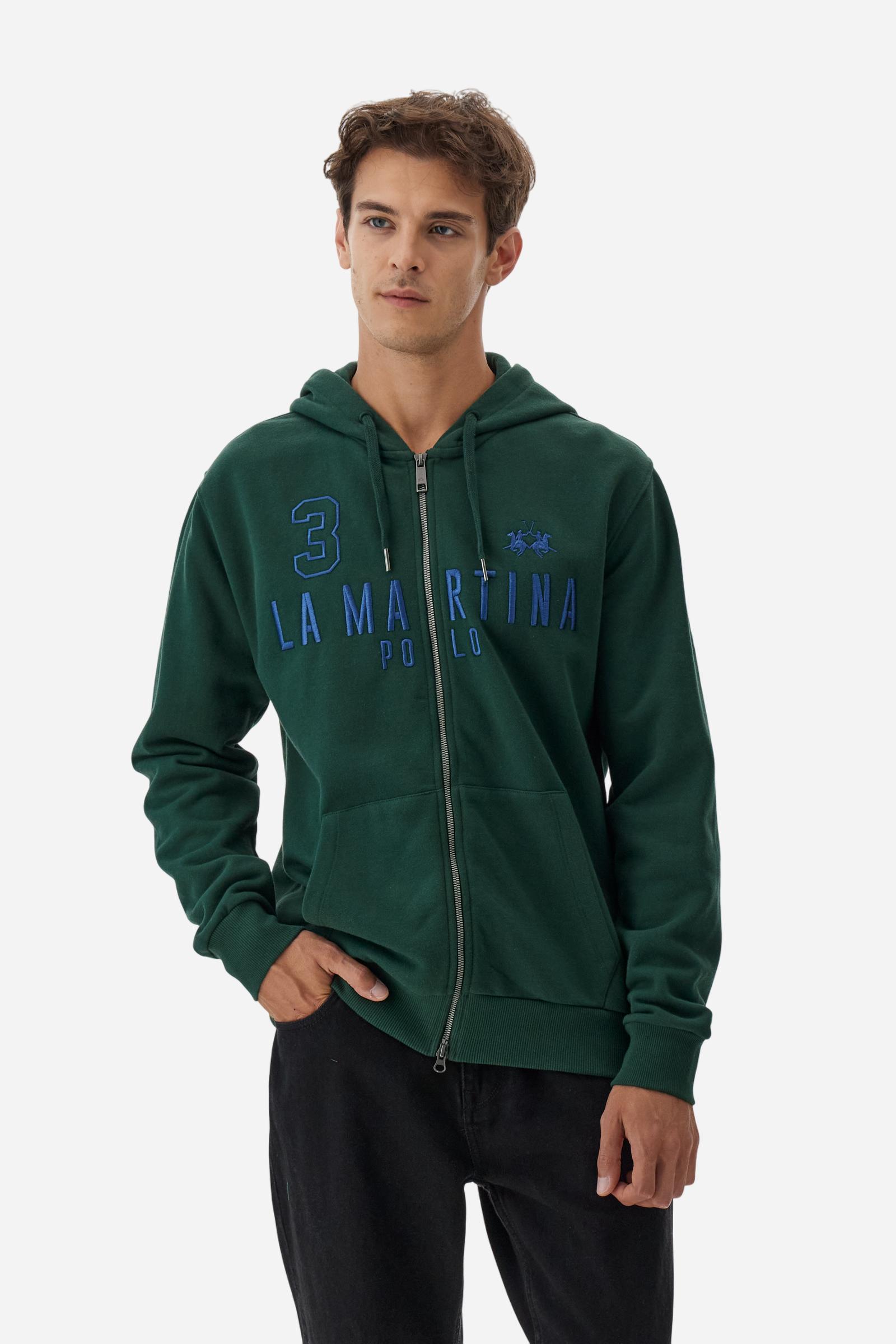 Men's long-sleeved hoodie in solid colour, made from soft 100% cotton fleece with a velvety touch. The model features a customised front zip and an adjustable hood with drawstring. Hem and cuffs in tone-on-tone rib. Iconic brand graphics stand out on the chest, embroidered with numbers and lettering. Regular fit ensuring comfort and freedom of movement. Model wears size L. - Sycamore