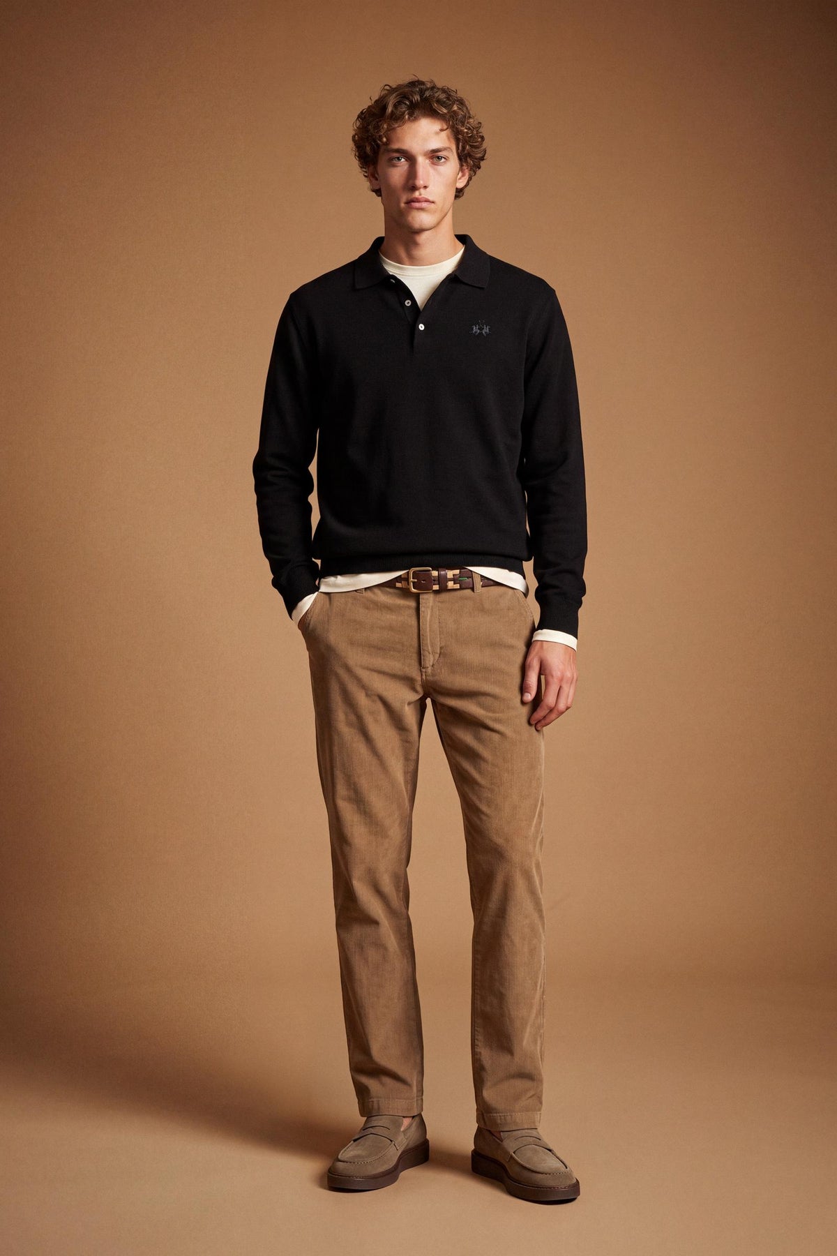 Men's long-sleeve polo made from 100% merino wool offers a comfortable fit, classic knitted collar, ribbed cuffs, and a subtle embroidered logo on the chest. - Black