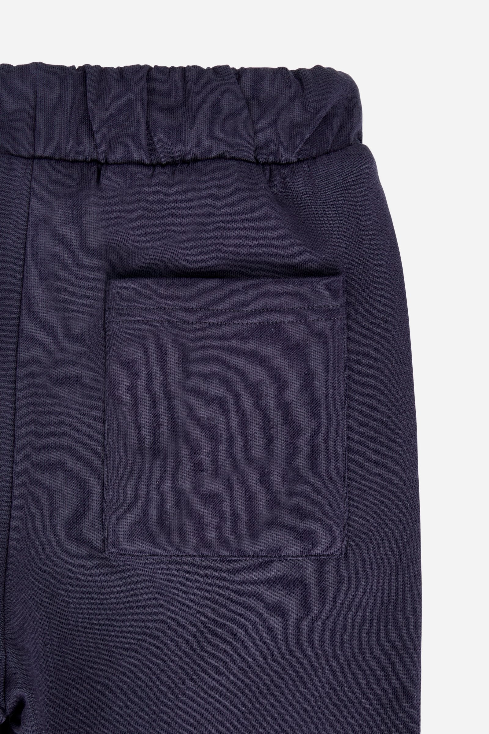 Bermuda shorts for boys made from soft 100% cotton fleece in a solid colour. The style features a clean, essential design, with an elasticated waist adjustable by drawstring and practical side pockets. A patch pocket is placed on the back, while the contrast embroidered maxi logo at the leg hem adds a distinctive and recognisable detail. A comfortable, versatile garment, ideal for leisure time. - Navy