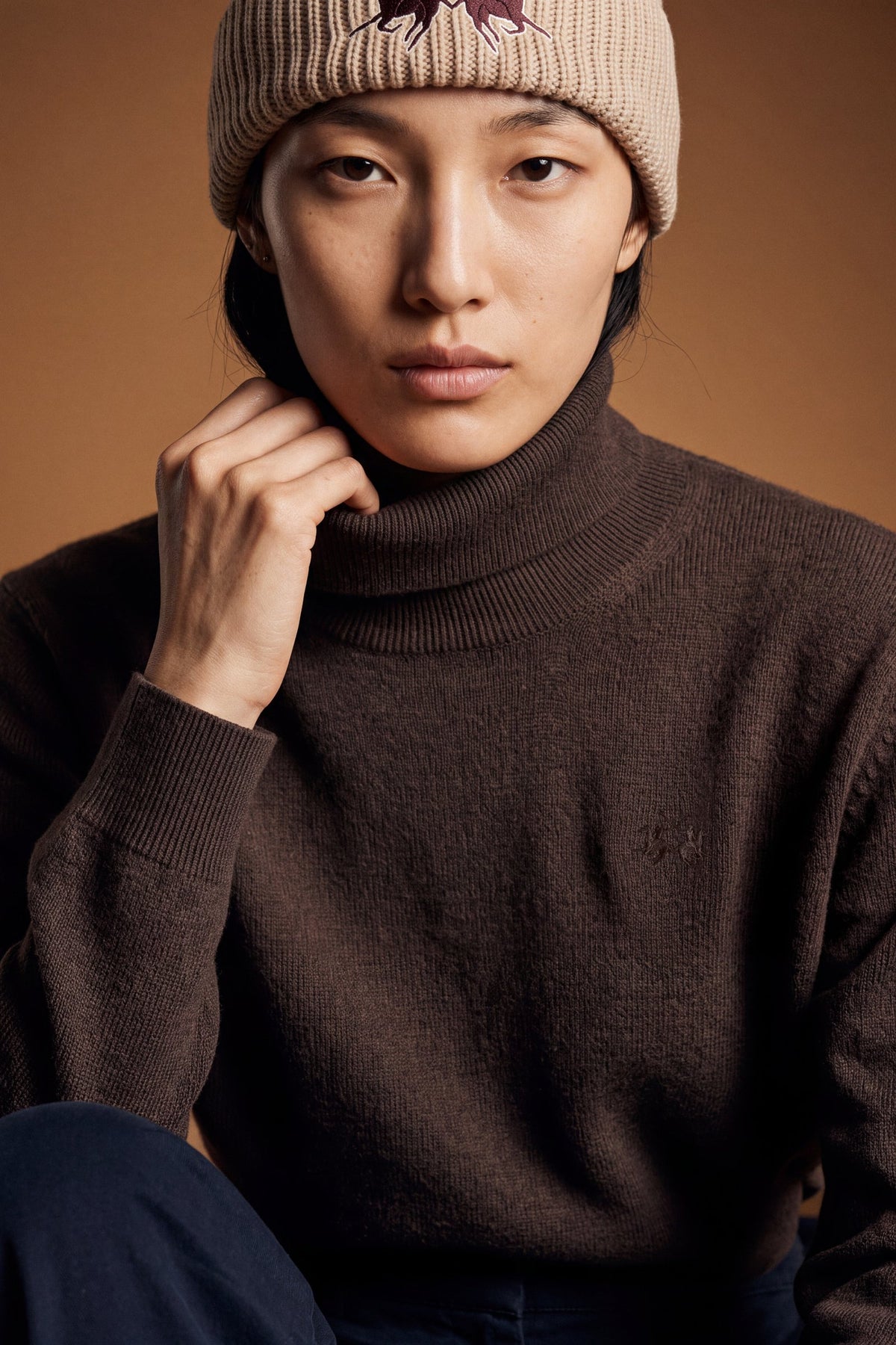 Women's lambswool turtleneck sweater with a soft, ribbed collar, fitted bust, ribbed cuffs and hem, and subtle embroidered logo for a clean, elegant look. - Hot Fudge