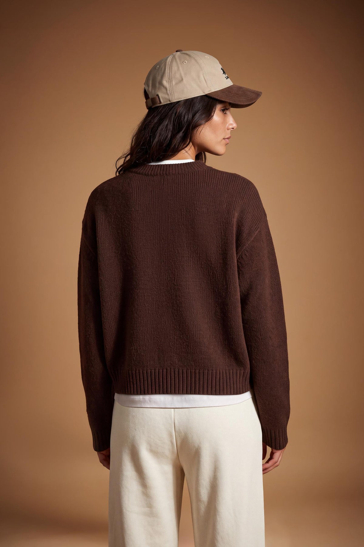 Women's long-sleeve sweater in soft 100% merino wool with a relaxed, slightly oversized fit, V-neck, ribbed cuffs and hem, and a modern cropped length. - Hot Fudge