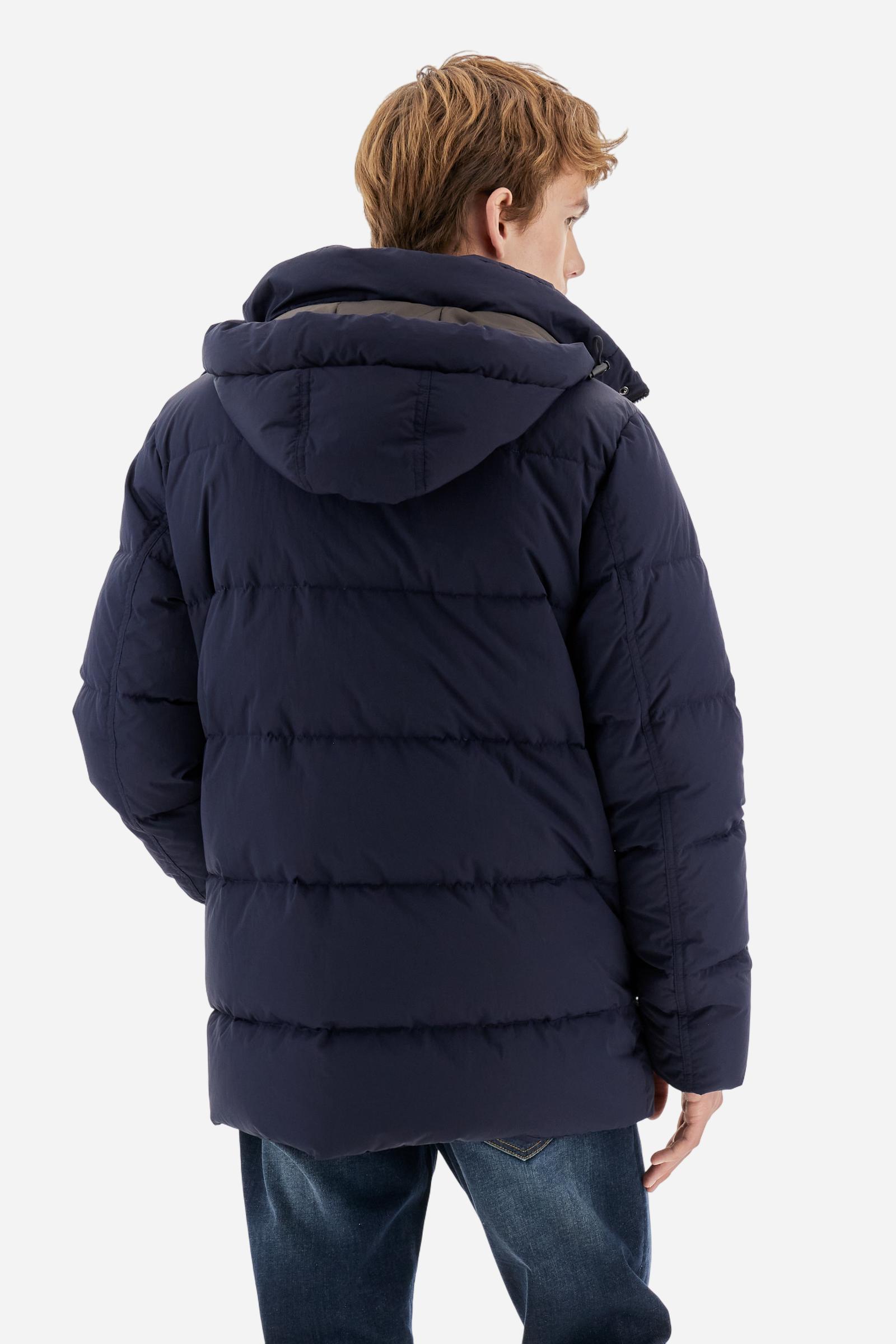 Men's long down jacket in solid crinkled nylon with detachable hood. Filled with down and fully lined in contrast, designed to provide warmth and lightness. The removable hood is adjustable with elastic drawstrings. Double zip closure with exclusive carabiner puller. Inside placket features contrasting La Martina embroidery, while a logo patch on the left sleeve completes the garment. Designed to combine urban functionality with technical performance. Regular, comfortable fit. Model wears size L. - Navy