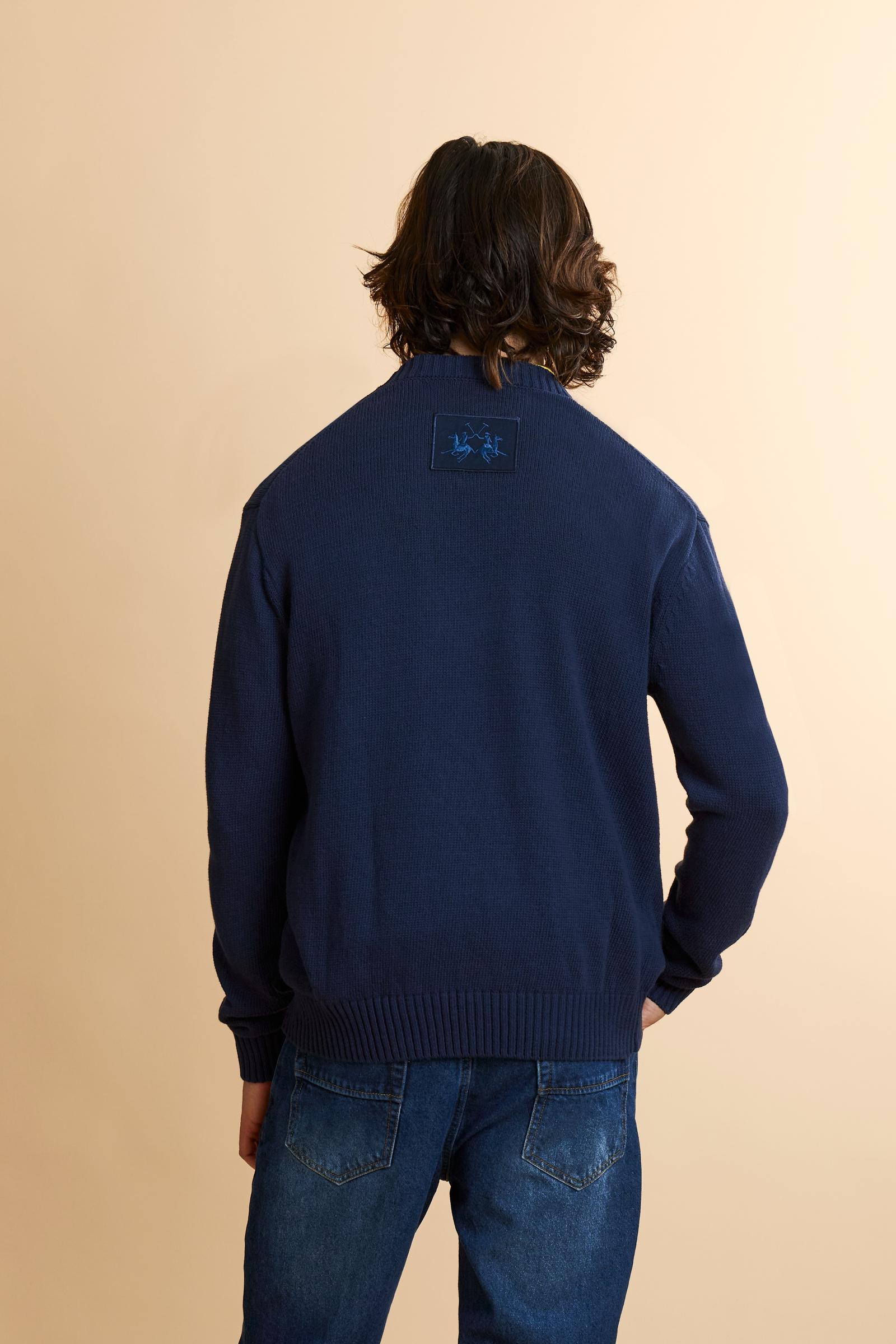 Men’s long-sleeved sweater made with gauge 5 knit in solid-color pure cotton yarn. The particular structure of the knit gives the garment a substantial yet soft hand feel. The clean, essential design is defined by a crew neck, ribbed cuffs, and hem. The fit is regular and relaxed, with a well-positioned shoulder that keeps the silhouette neat. On the back, just below the neckline, the embroidered logo patch adds a discreet brand signature. The model is wearing size L. - Navy