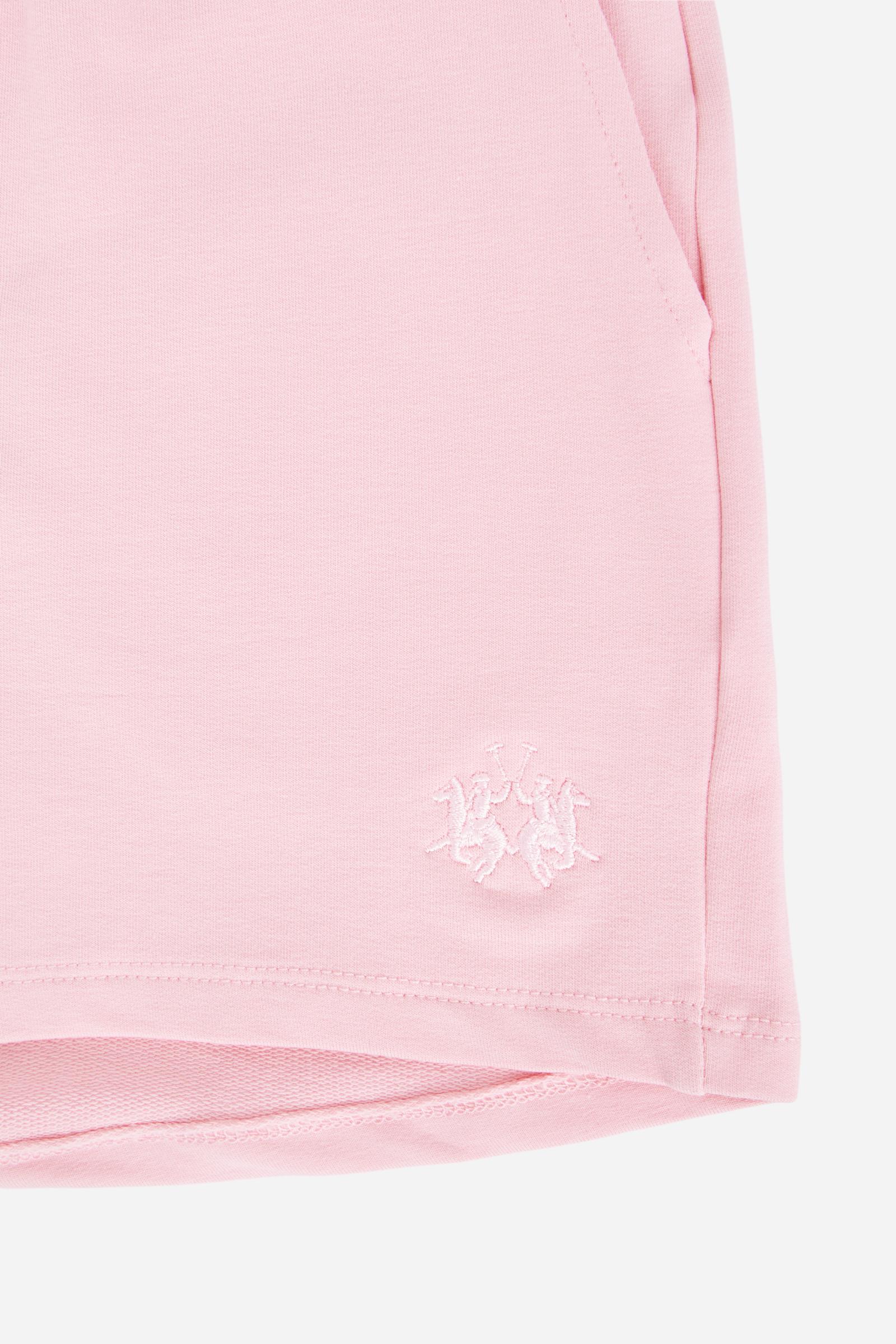 Bermuda shorts for girls made from soft 100% cotton fleece in a solid colour. The style features a regular fit, short leg and elasticated waist with adjustable drawstring. The small contrast embroidered brand logo on the left leg adds a discreet and distinctive detail. A comfortable, versatile garment, ideal for casual and sporty looks. - FairTale