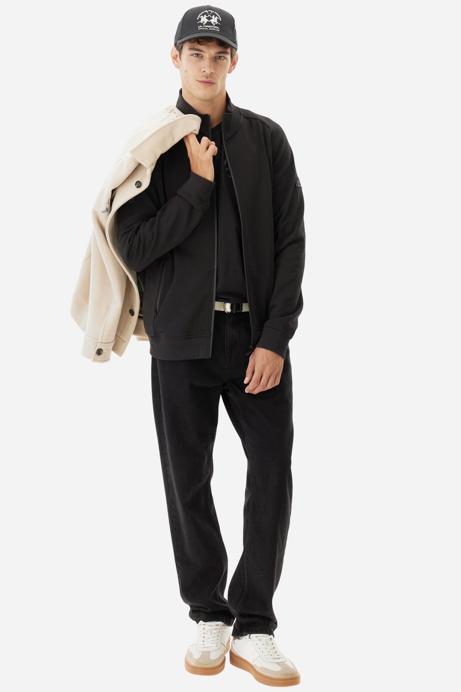 Men's long-sleeved sweatshirt in solid cotton-blend interlock with semi-glossy finish. Features customised front zip, stand-up collar, hem and cuffs in tone-on-tone rib. Large semi-gloss La Martina transfer on the back celebrates the brand's identity, while two patches on the right sleeve recall the Argentine polo association. Regular fit for a practical yet refined style. Model wears size L. - Black