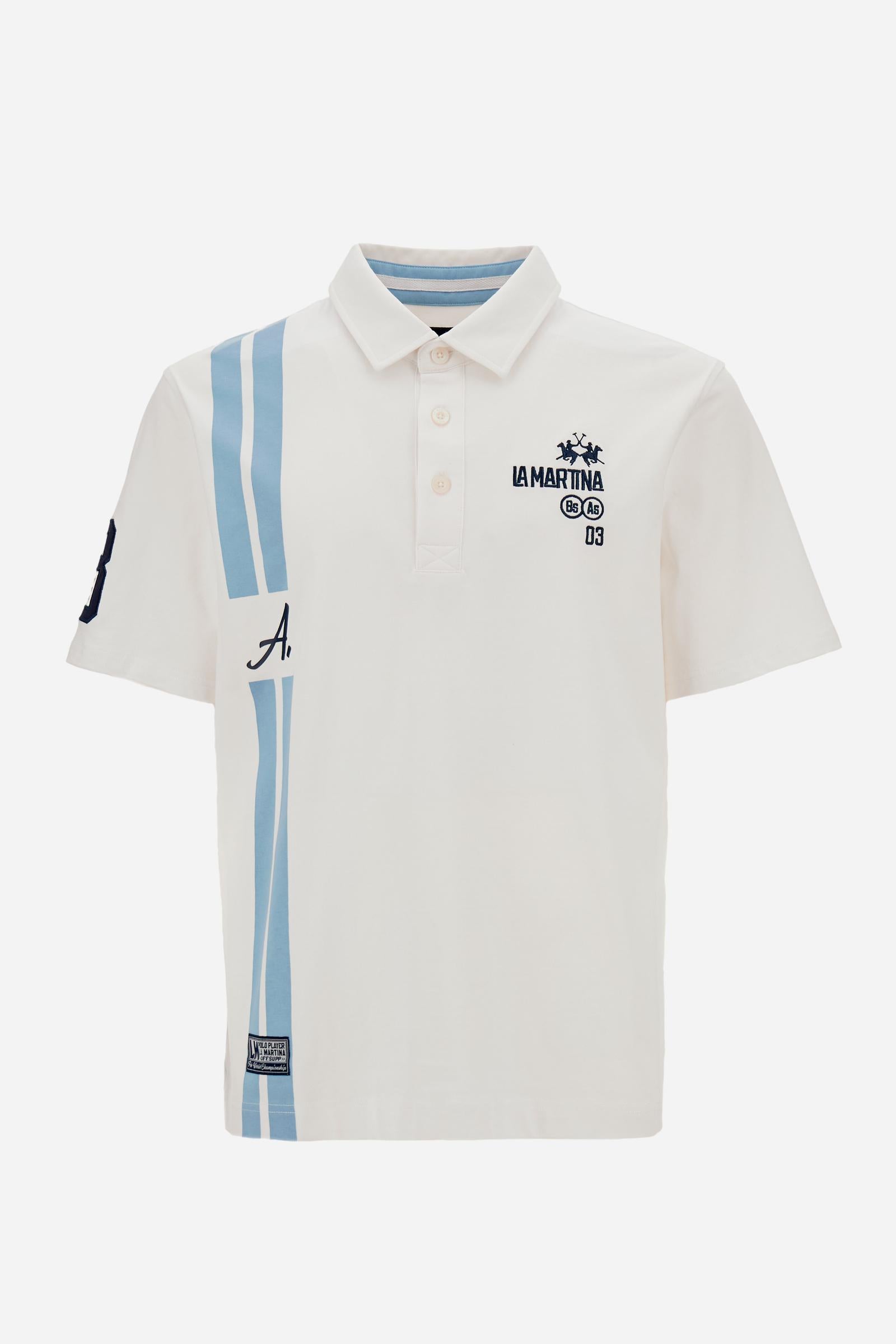 Men’s heavy cotton jersey polo with three-button placket and striped details. Celebratory maxi graphic and bold lettering. - Optic White                                                                                                                                                                                                                                                                                                                                                                                        