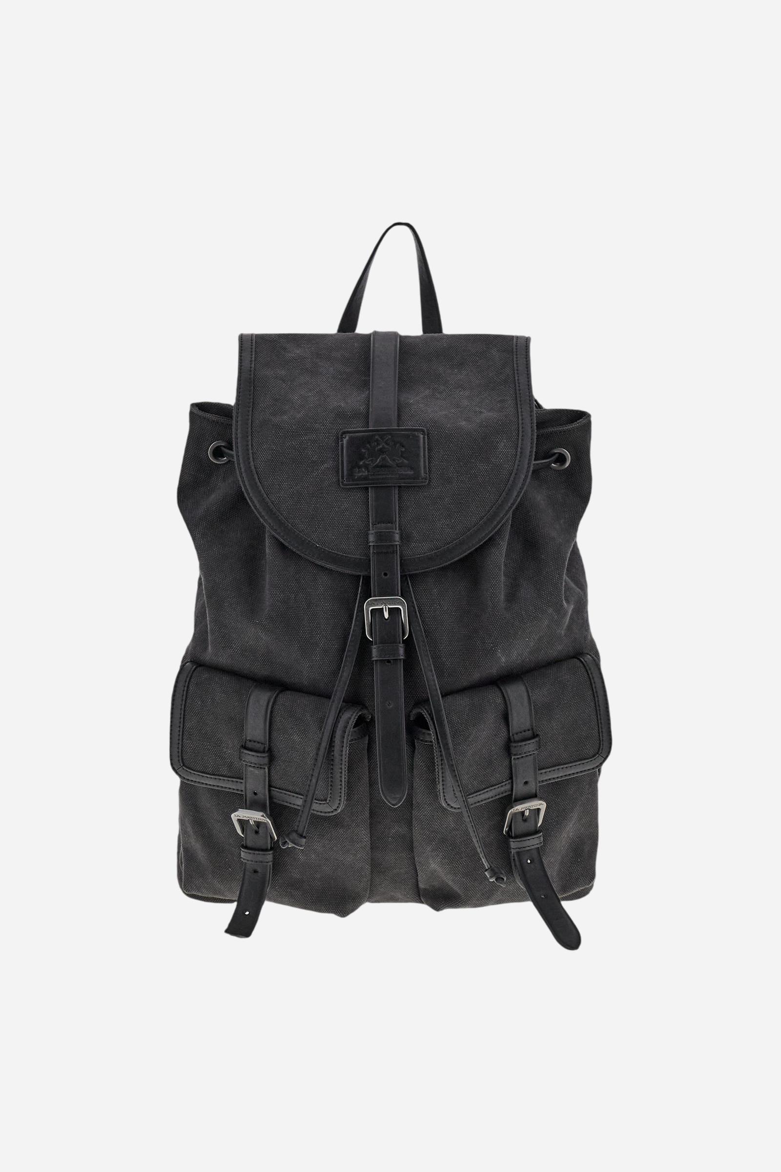 Backpack in washed canvas with leather details, resistant and practical, designed for travel lovers. Featuring a double closure with drawstring and flap with magnetic button, large front pockets for extra space, and a hot-stamped logo on the leather tag of the flap. Dimensions:31 x 40 x 14 - Black