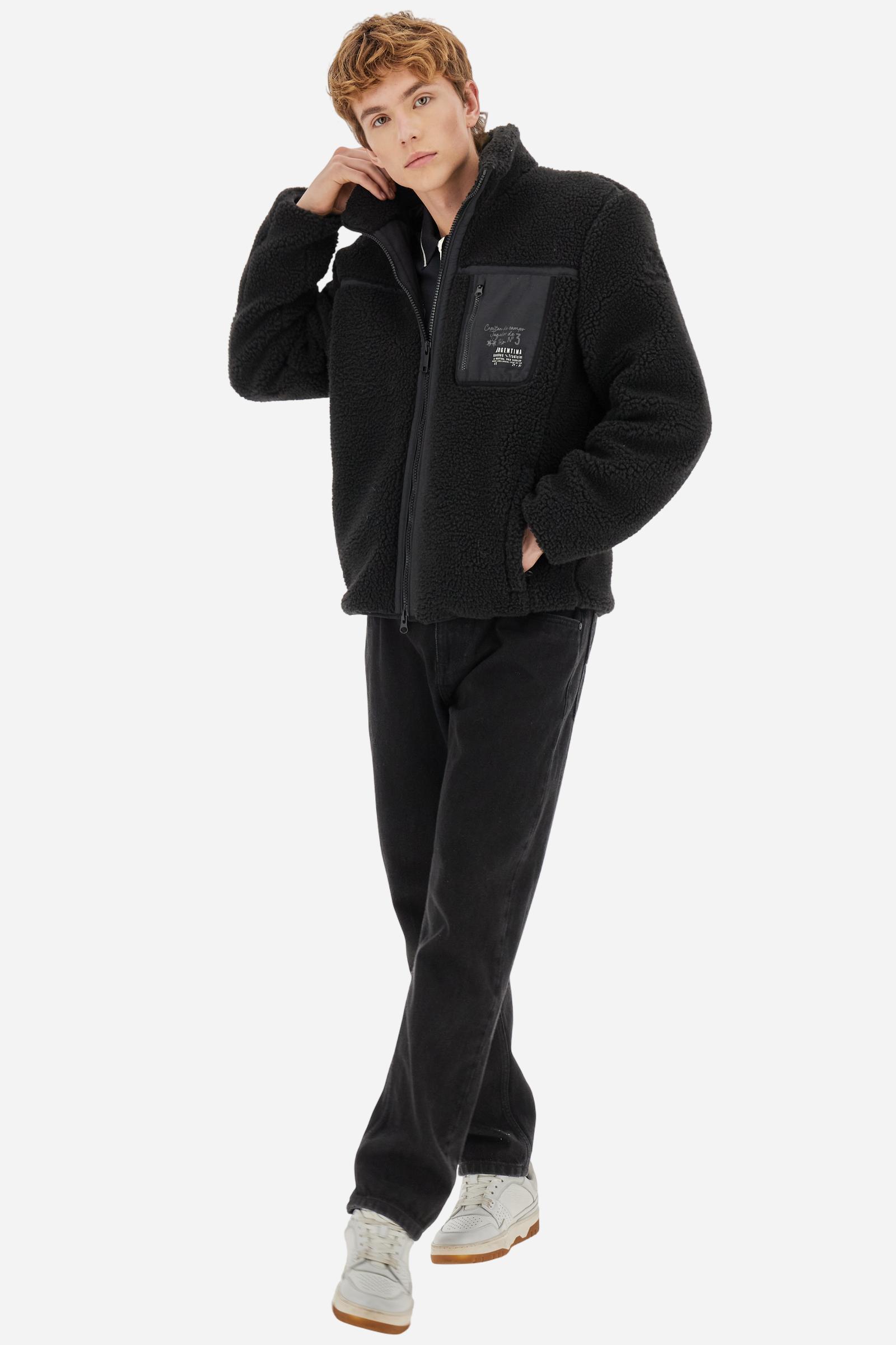 Men’s teddy jacket in 100% polyester with high collar and full lining. Front closure with customized tone-on-tone zip. Finished with matte nylon trims on seams and edges, also used for the zipped chest pocket. High collar offers extra wind protection. Patches inspired by Argentina and Jugador de Polo on sleeve and chest pocket. Regular, straight fit. Model wears size L. - Black