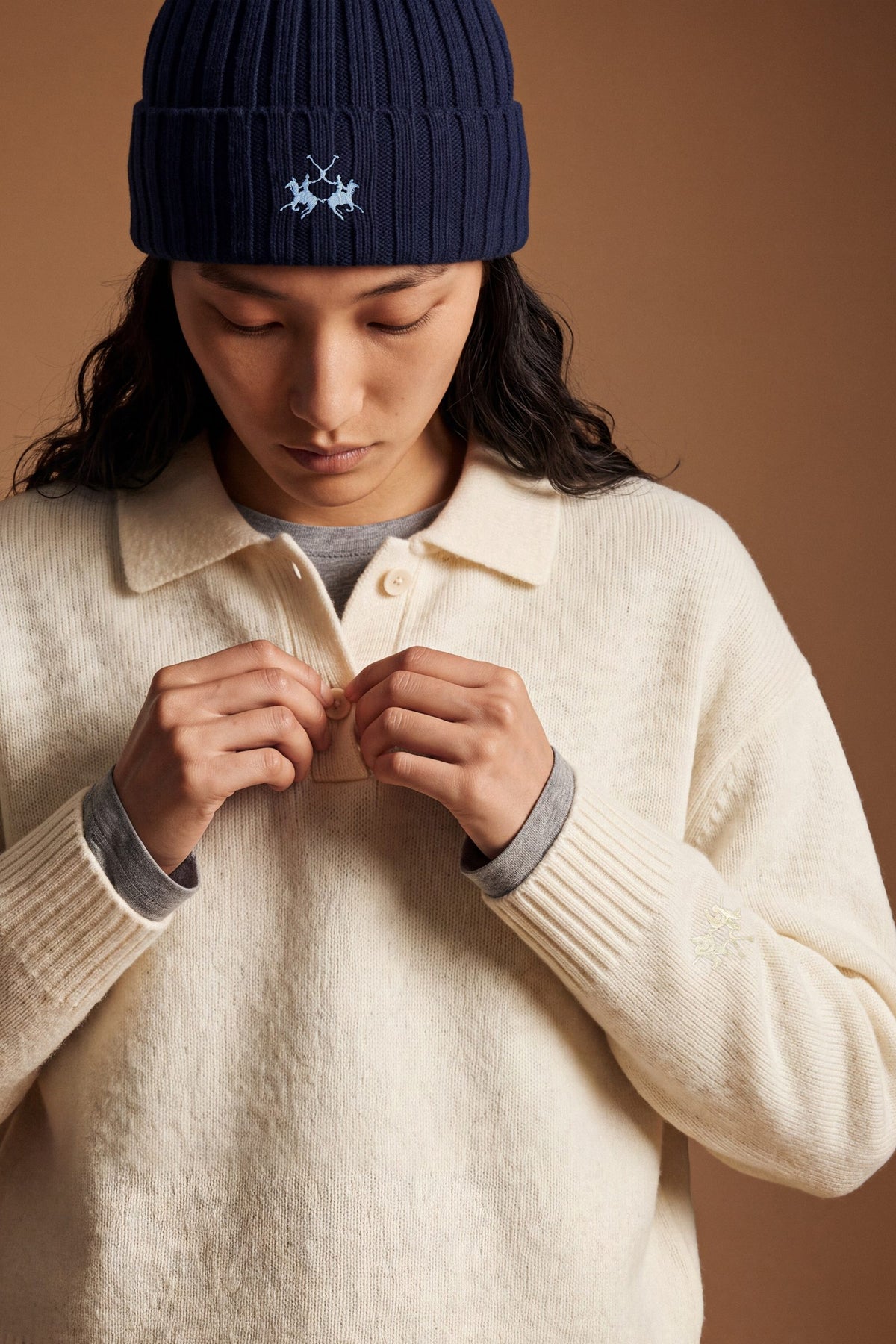 Women's long-sleeve knitted polo in soft lambswool blend, featuring a relaxed cropped fit, ribbed cuffs, shirt-style collar, and smooth, compact knit surface. - Antique White