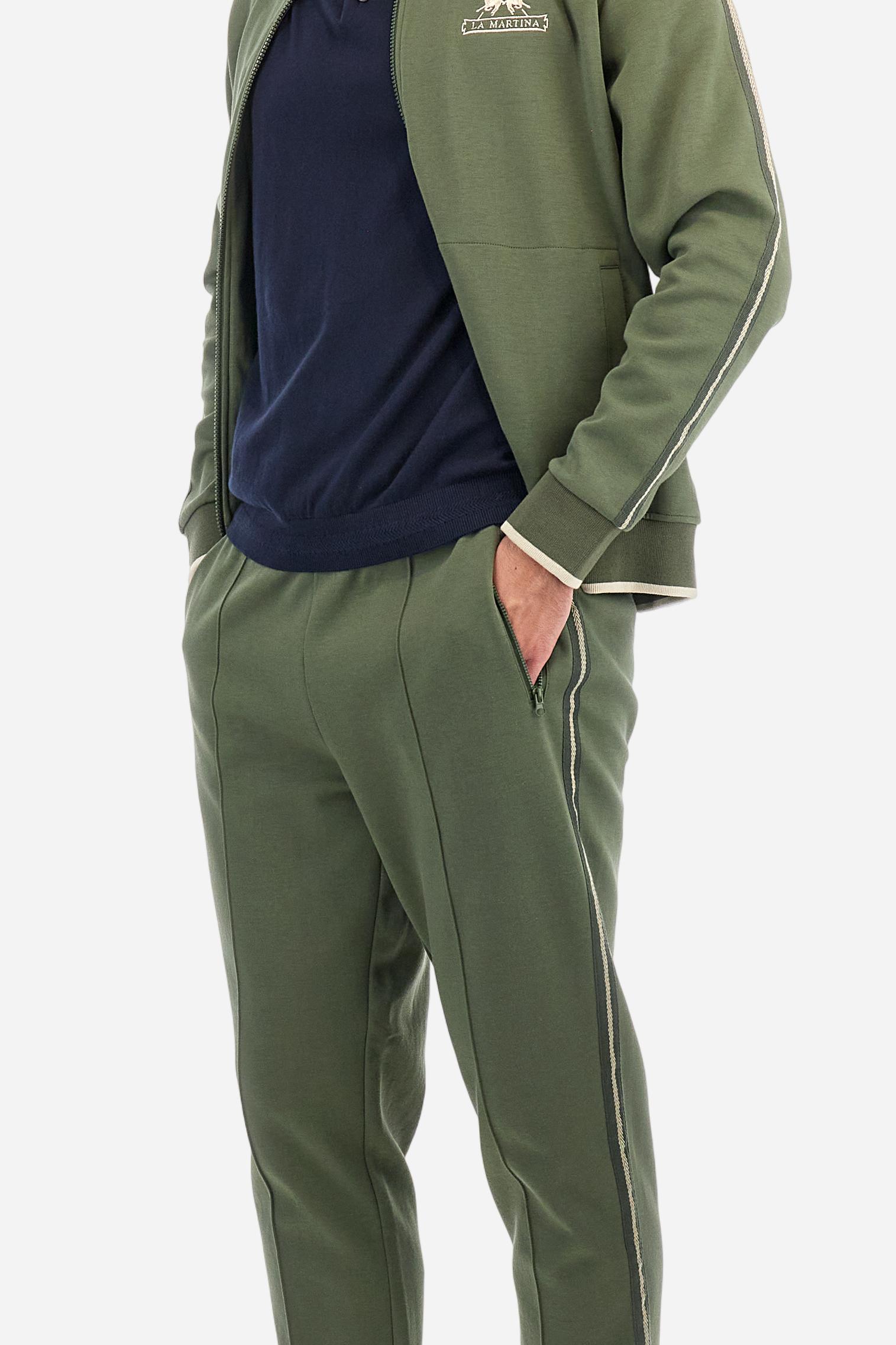 Single-colour men's polo shirt with short sleeves. Made of knitted cotton yarn. Two-button fastening and ribbed collar with contrasting stripes on the bottom. The cuffs of the sleeves are ribbed, as is the band at the bottom, which is embellished in the centre with a band featuring a herringbone stitch. A contrasting coloured jersey ribbon is applied to the inside of the collar. The logo is embroidered on the left side of the chest in contrasting thread. Regular fit. The model is wearing a size L. - Navy