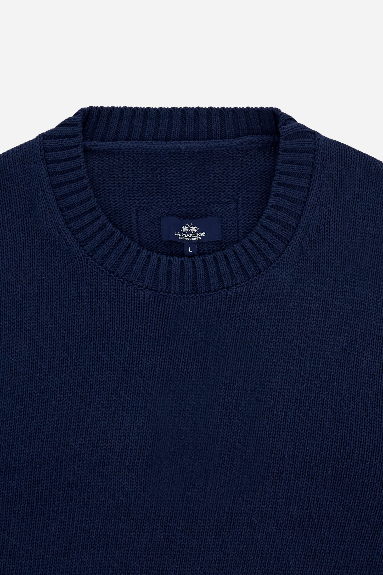 Men’s long-sleeved sweater made with gauge 5 knit in solid-color pure cotton yarn. The particular structure of the knit gives the garment a substantial yet soft hand feel. The clean, essential design is defined by a crew neck, ribbed cuffs, and hem. The fit is regular and relaxed, with a well-positioned shoulder that keeps the silhouette neat. On the back, just below the neckline, the embroidered logo patch adds a discreet brand signature. The model is wearing size L. - Navy