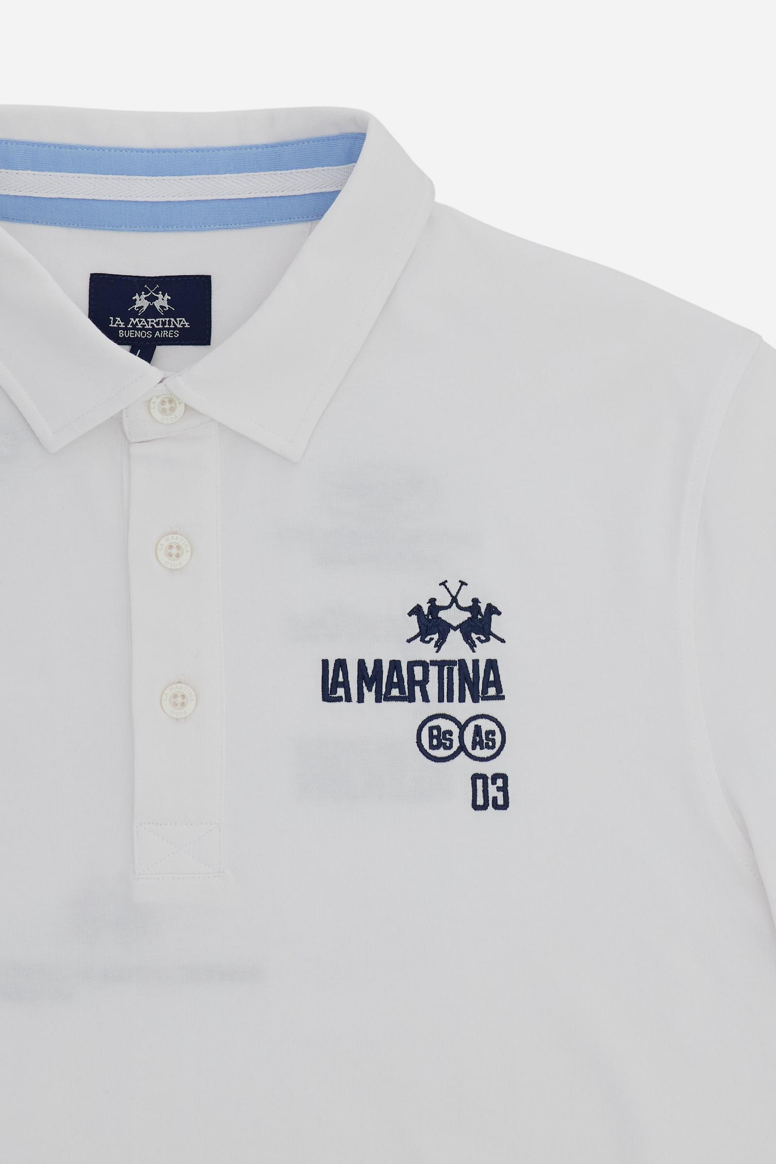 Men’s heavy cotton jersey polo with three-button placket and striped details. Celebratory maxi graphic and bold lettering. - Optic White                                                                                                                                                                                                                                                                                                                                                                                        