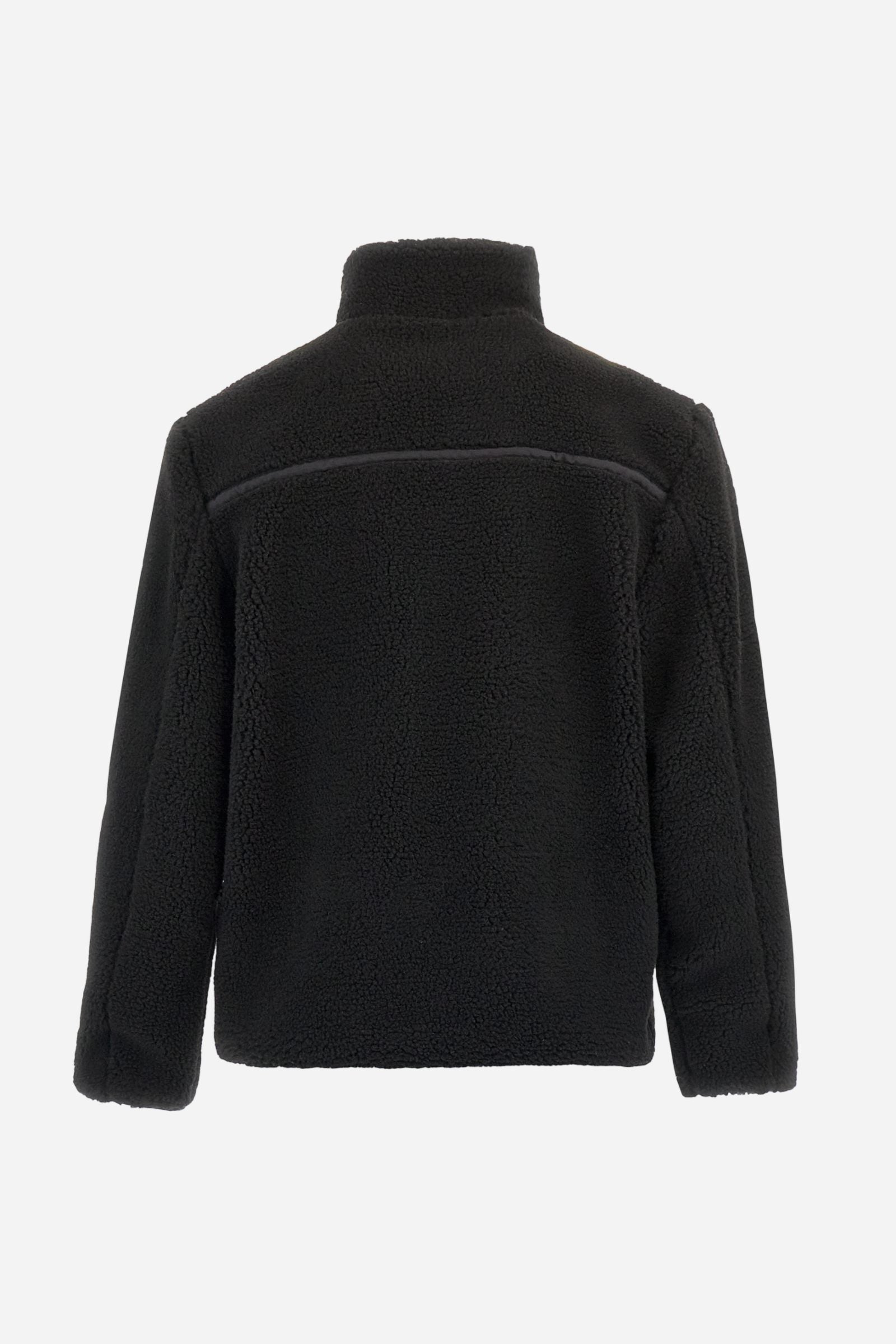 Men’s teddy jacket in 100% polyester with high collar and full lining. Front closure with customized tone-on-tone zip. Finished with matte nylon trims on seams and edges, also used for the zipped chest pocket. High collar offers extra wind protection. Patches inspired by Argentina and Jugador de Polo on sleeve and chest pocket. Regular, straight fit. Model wears size L. - Black