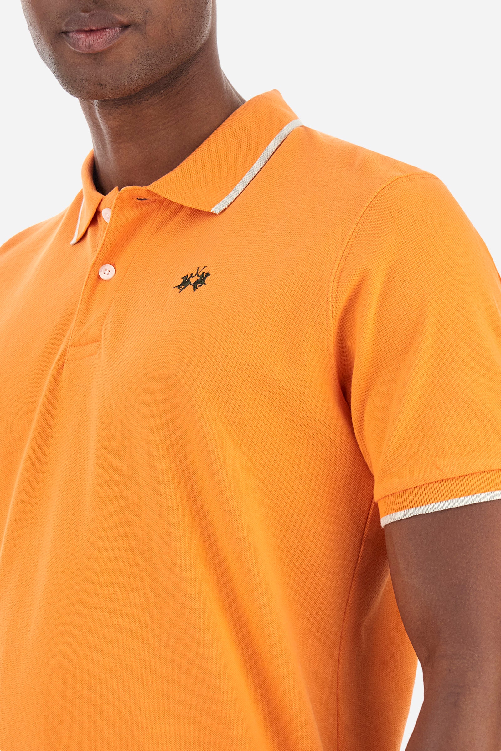 Men’s polo with short sleeves in stretch pique cotton. A classic La Martina, with a simple and linear style. The regular fit fits easily to any type of silhouette. A small La Martina logo is embroidered on the chest, in contrasting shades like the sleeve edge. The model is 187 cm tall and wears a size L. - Celosia Orange