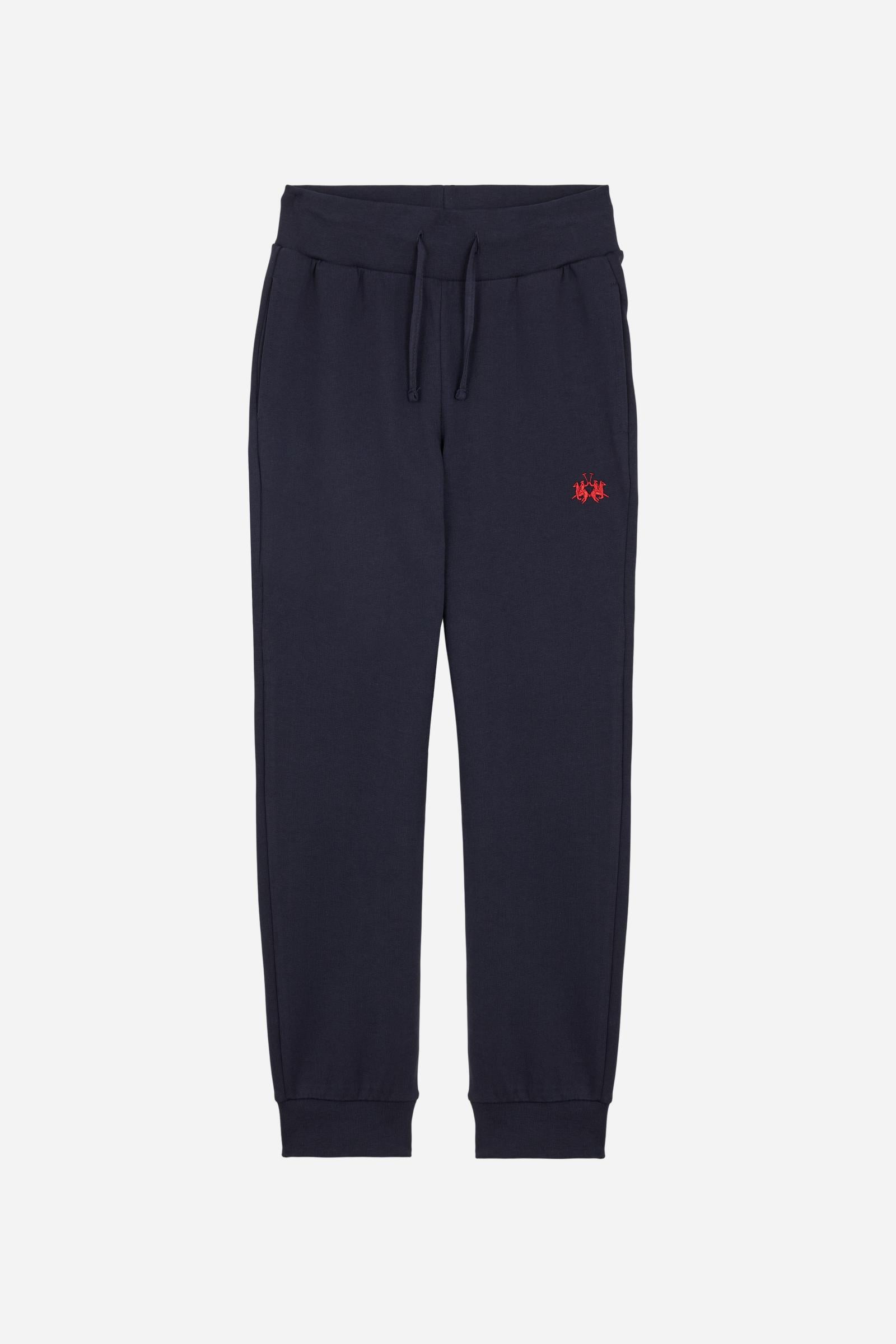 Jogger trousers for boys made from soft 100% cotton fleece in a solid colour. The style features a regular fit, a slightly tapered leg and an adjustable waist with flat drawstring. Side pockets and a patch pocket on the back add practicality, while the small contrast embroidered brand logo on the front completes the garment with a discreet, distinctive detail. - Navy