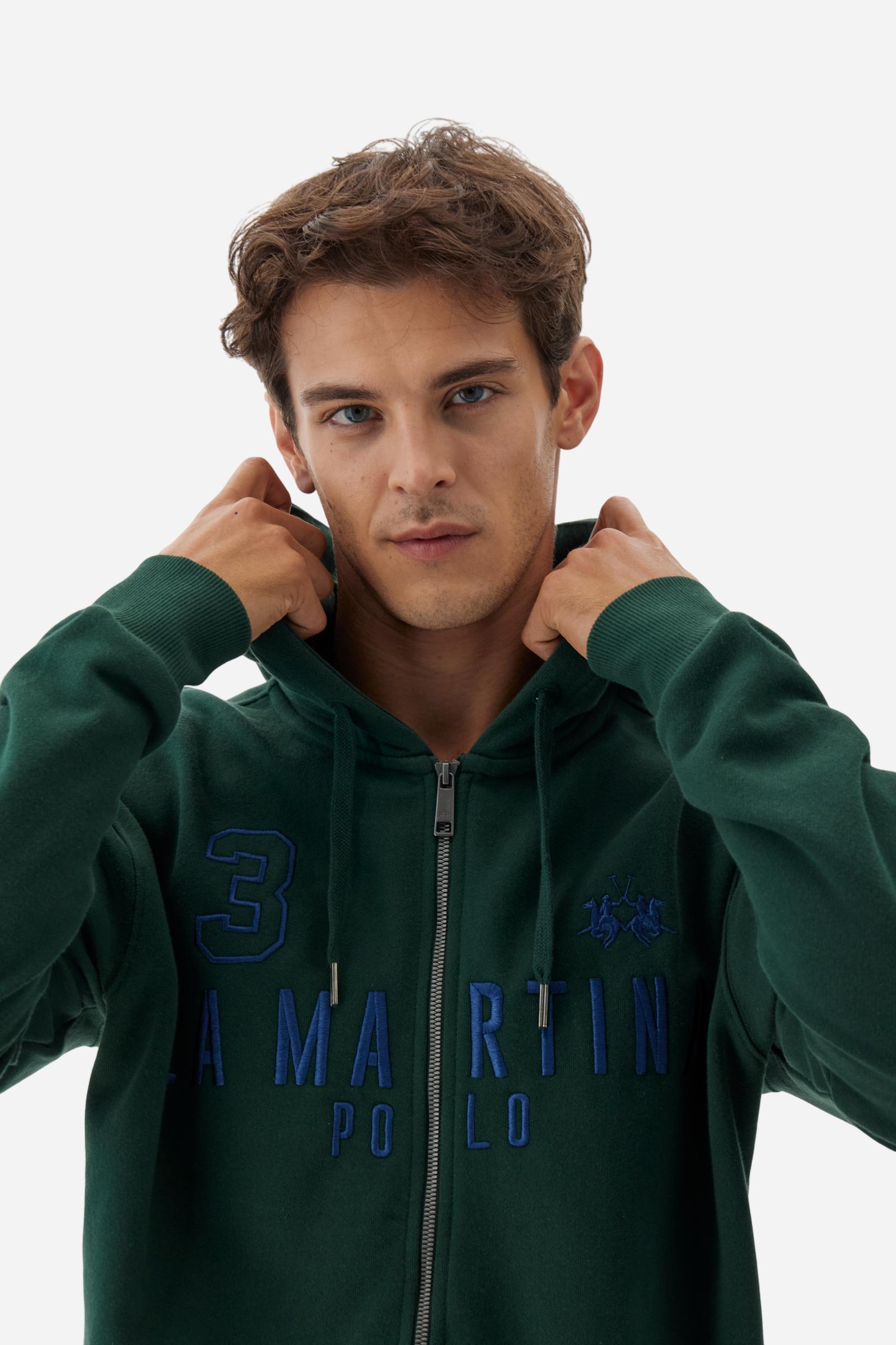 Men's long-sleeved hoodie in solid colour, made from soft 100% cotton fleece with a velvety touch. The model features a customised front zip and an adjustable hood with drawstring. Hem and cuffs in tone-on-tone rib. Iconic brand graphics stand out on the chest, embroidered with numbers and lettering. Regular fit ensuring comfort and freedom of movement. Model wears size L. - Sycamore